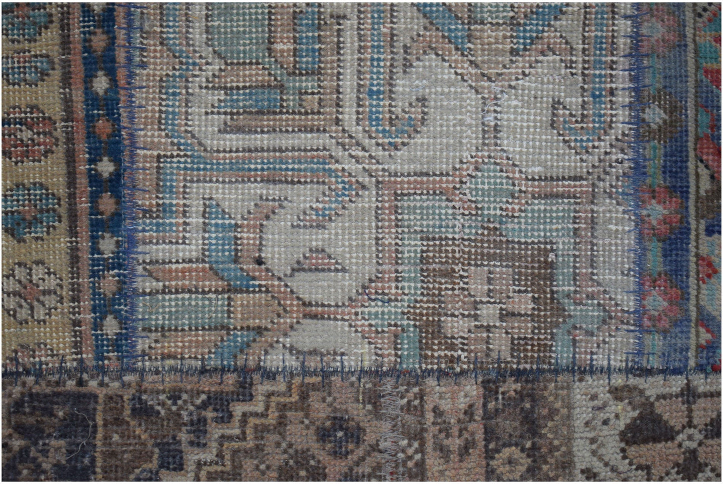A vintage patchwork runner featuring intricate geometric patterns in muted blue and brown tones.