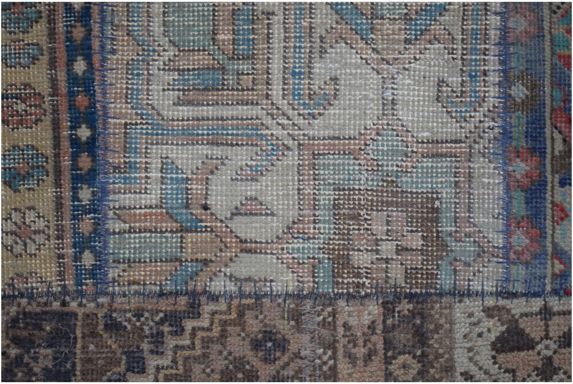 A vintage patchwork runner featuring intricate geometric patterns in muted blue and brown tones.