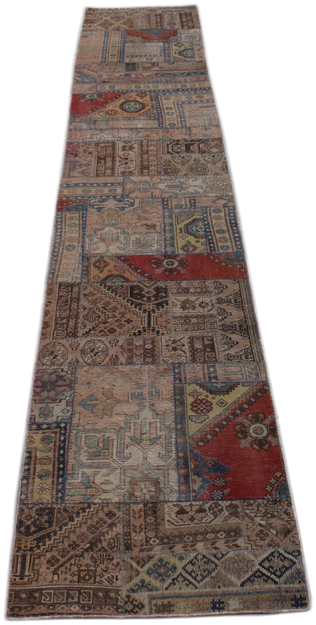 A handmade vintage patchwork runner rug featuring a variety of colorful, distressed wool patterns.