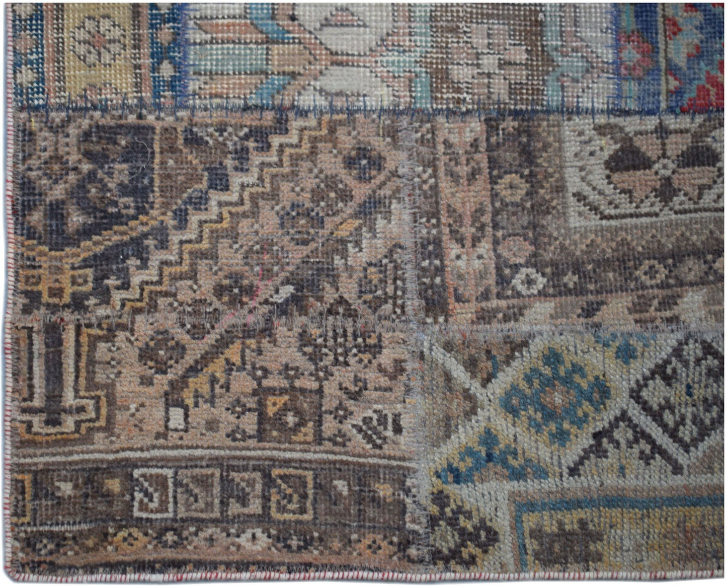 A handmade vintage patchwork runner featuring a variety of intricate, multi-colored wool patterns.