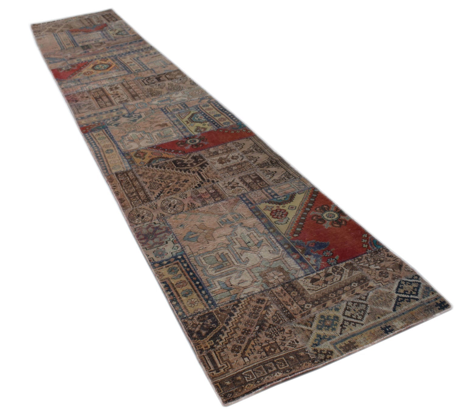 A long, handmade vintage patchwork runner rug featuring a variety of colorful, distressed patterns.