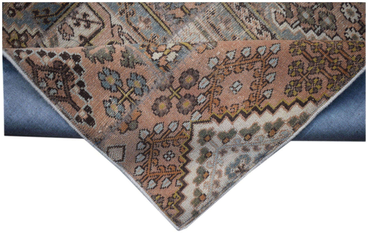A handmade vintage patchwork runner featuring intricate geometric patterns in muted earth tones.