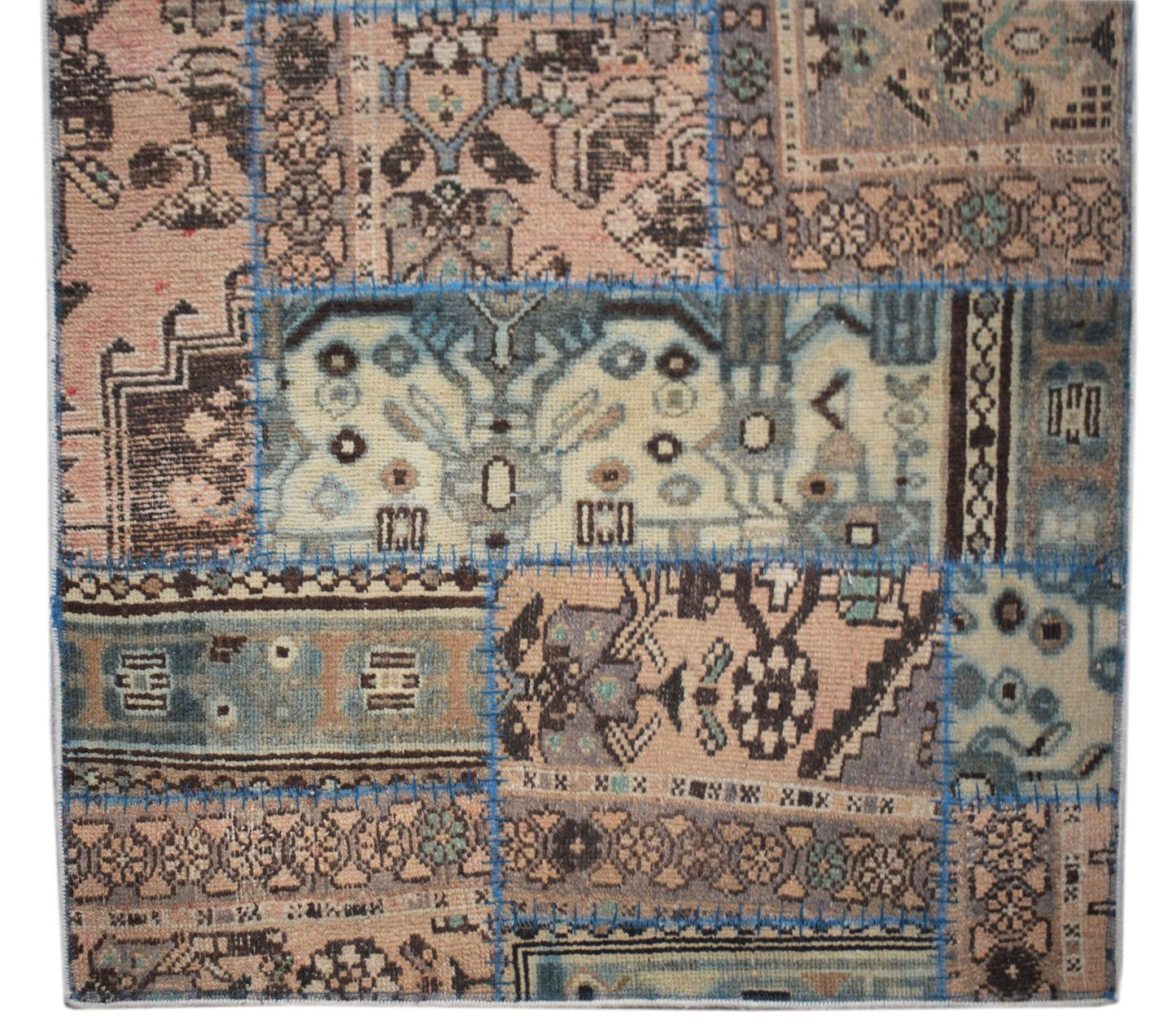 A handmade patchwork runner rug featuring various vintage wool patterns in muted earth tones.