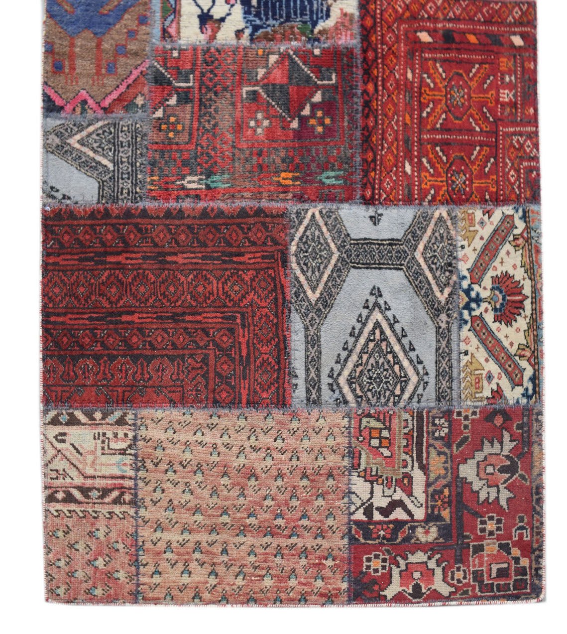 A handmade wool patchwork runner featuring a variety of vintage Afghan rug patterns in red and blue.