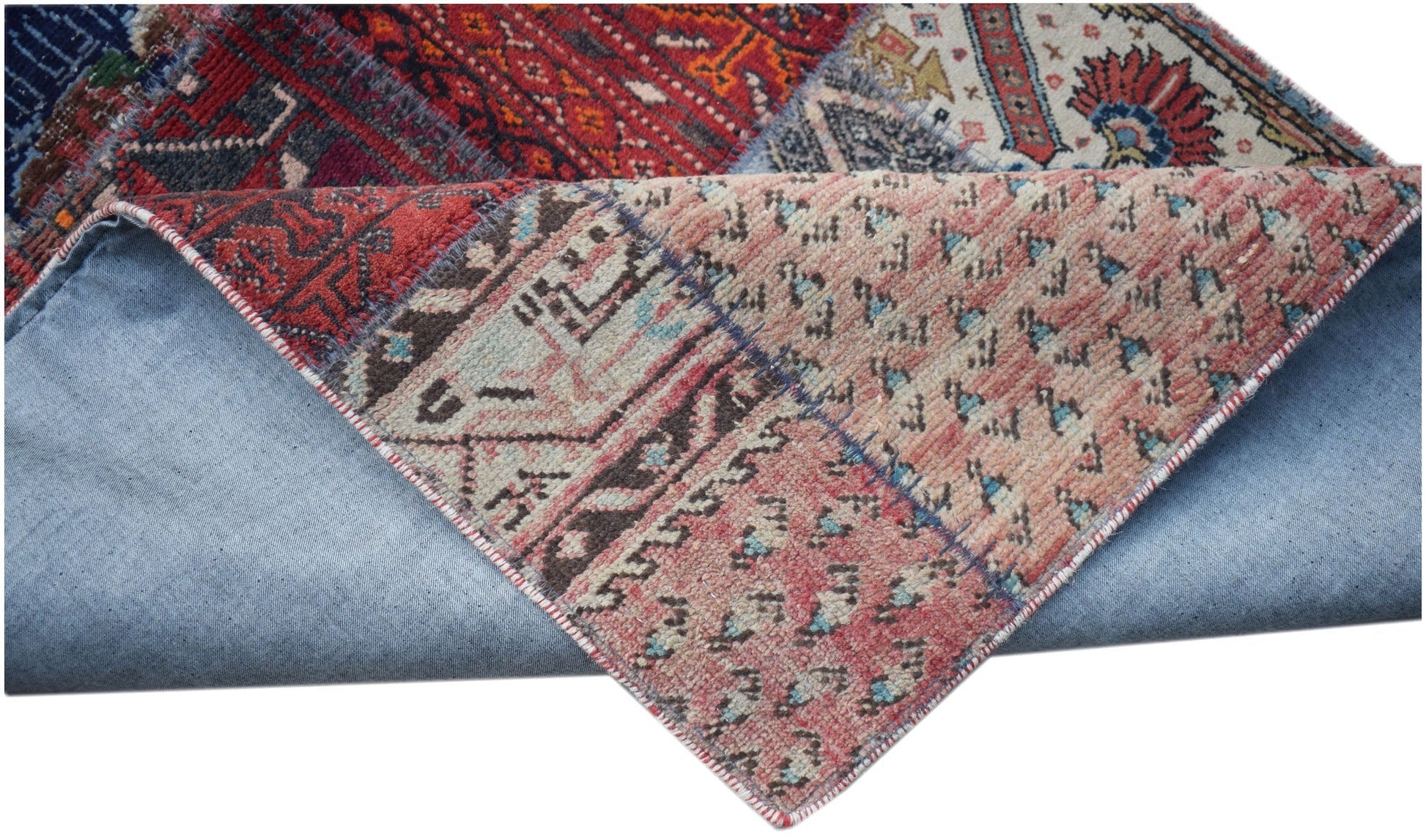 A handmade vintage patchwork runner made of wool with a cotton base and folded corner.