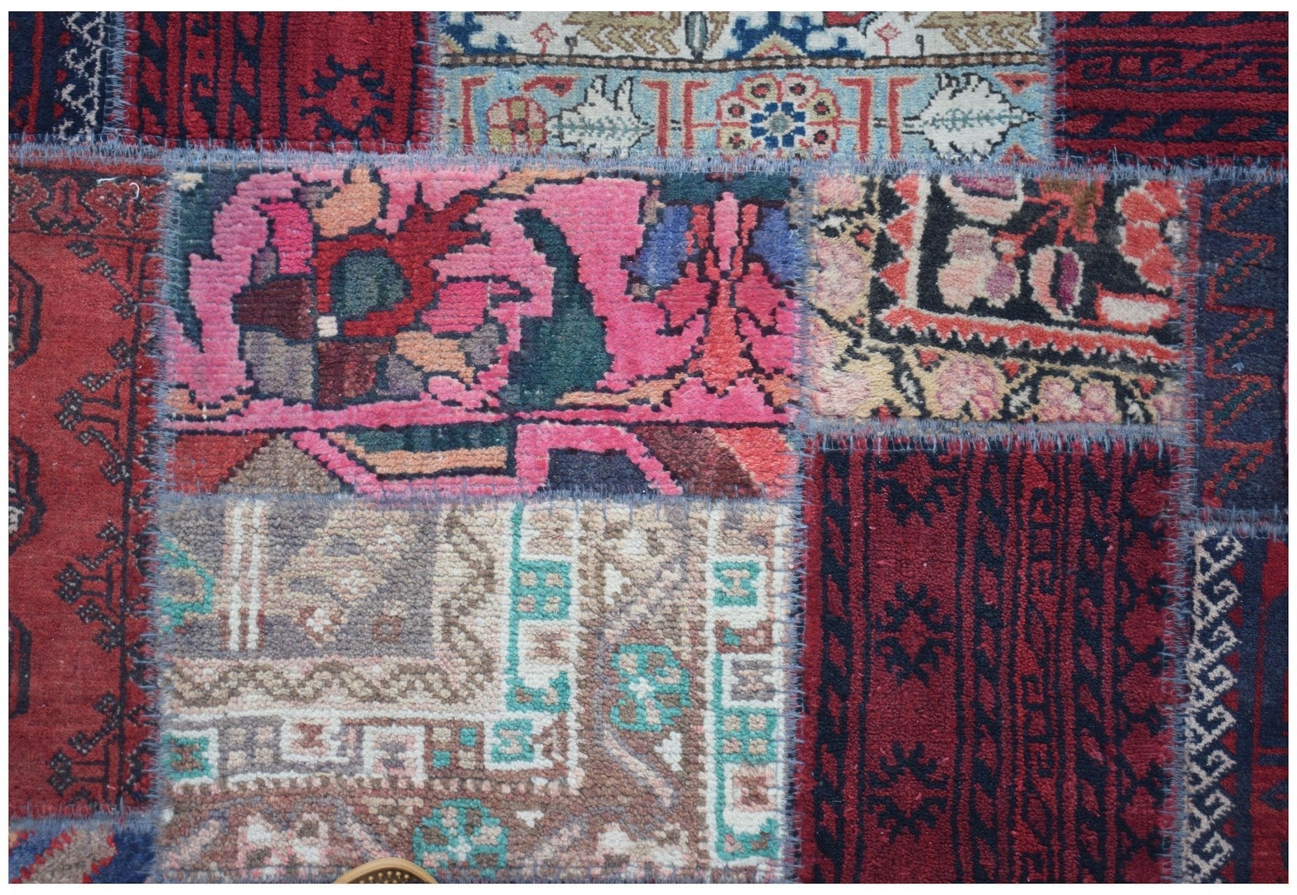 A handmade vintage patchwork runner featuring a vibrant mix of wool rug fragments in various colors.