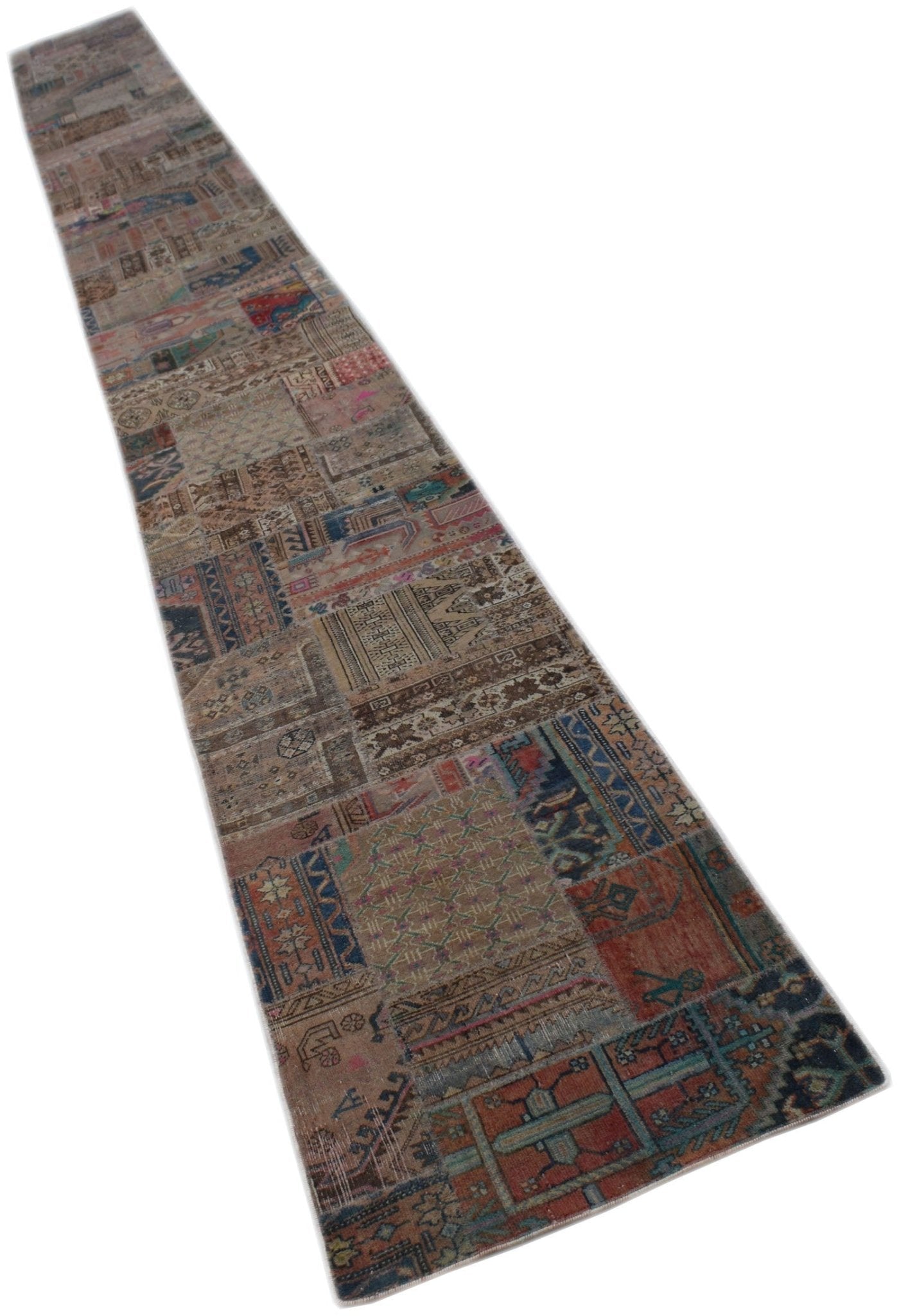 A long, handmade vintage patchwork runner rug featuring a variety of colorful, distressed patterns.