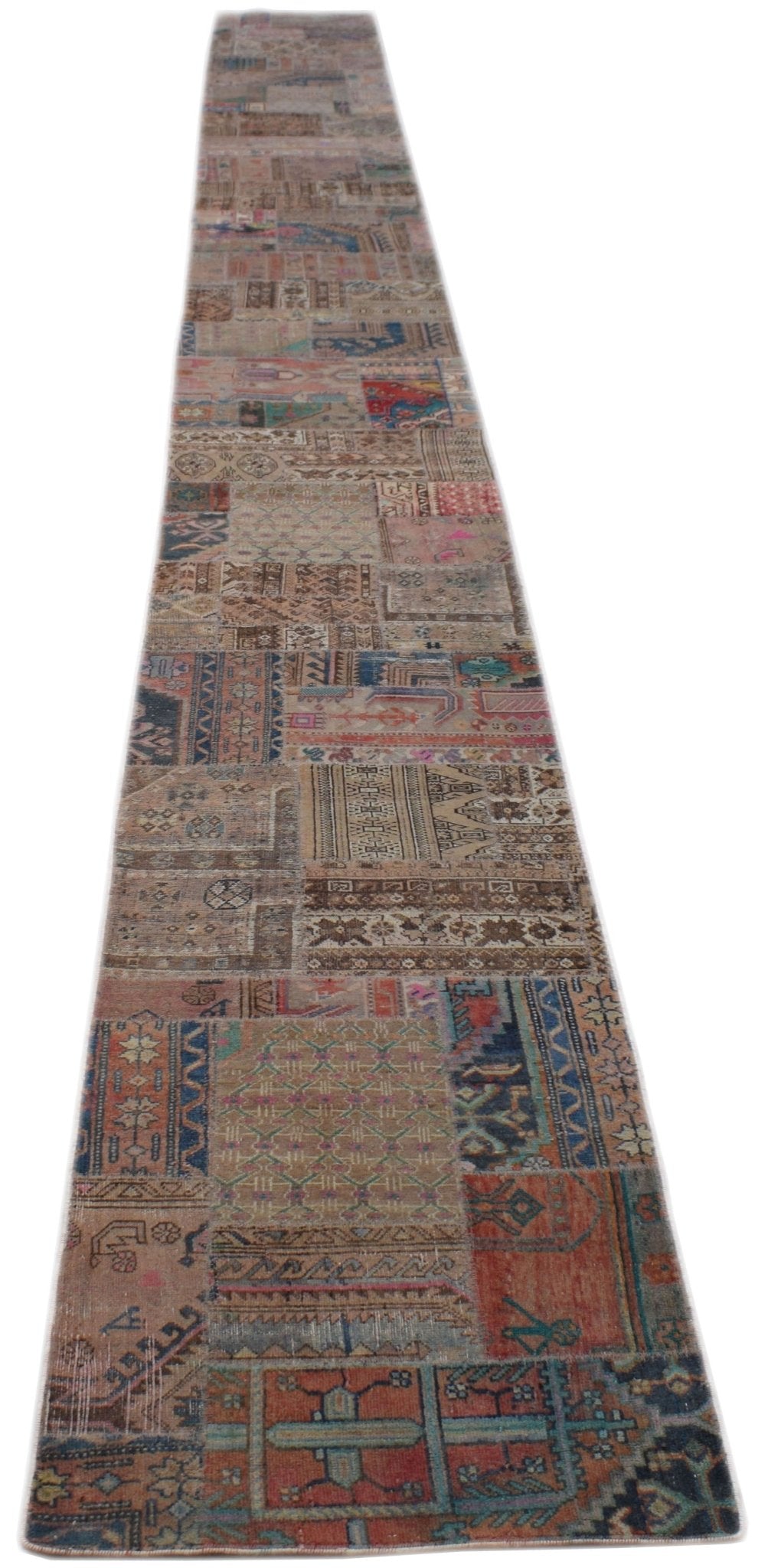 A long, handmade vintage patchwork runner rug featuring a variety of colorful wool patterns.