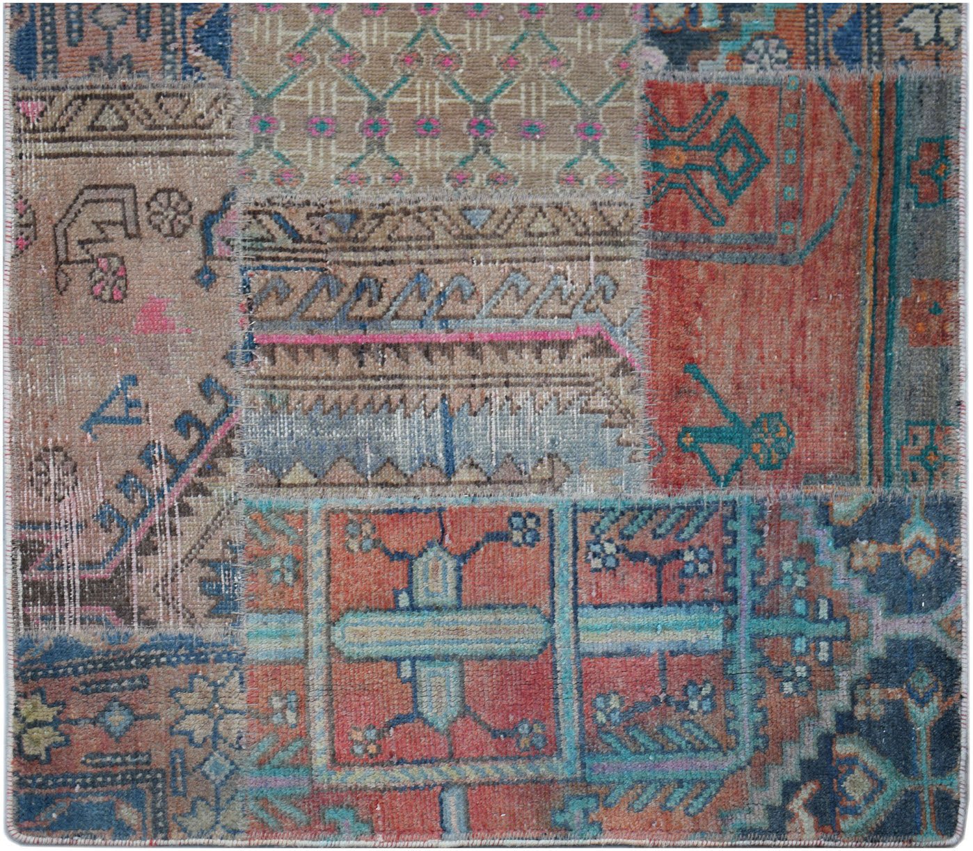 A handmade vintage patchwork runner featuring a variety of colorful, distressed wool rug fragments.