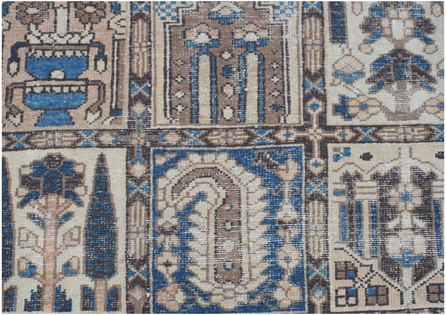 A vintage Persian Bakhtiari rug featuring a geometric grid of floral and paisley motifs.