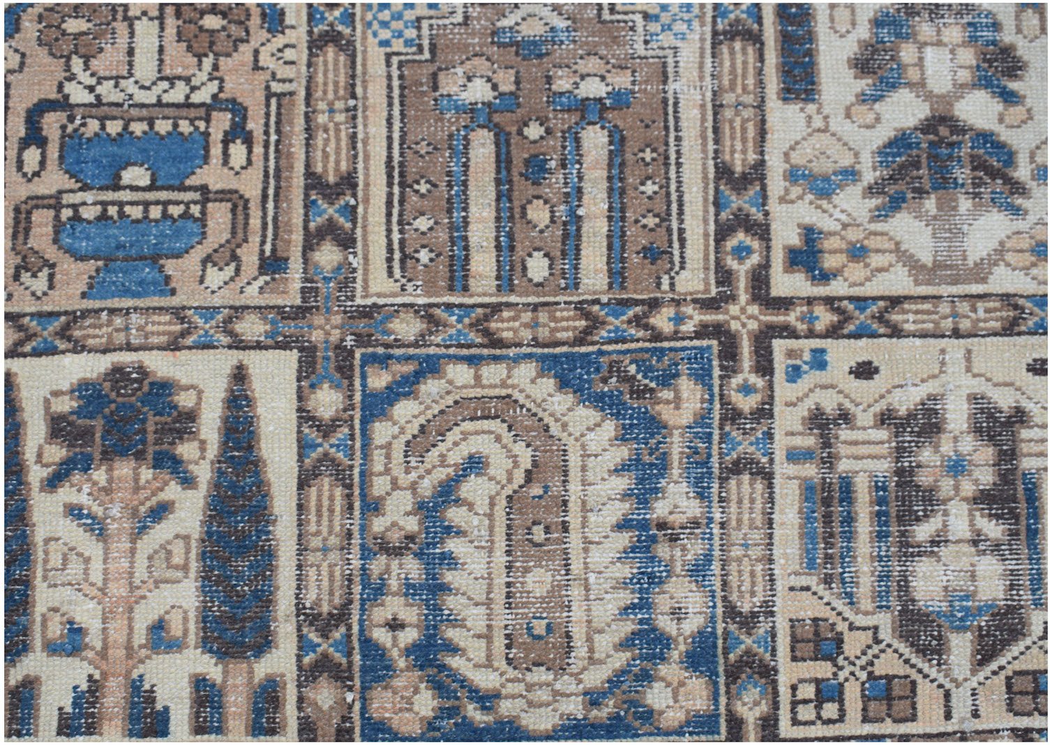A vintage Persian Bakhtiari rug featuring a geometric grid of floral and paisley motifs.