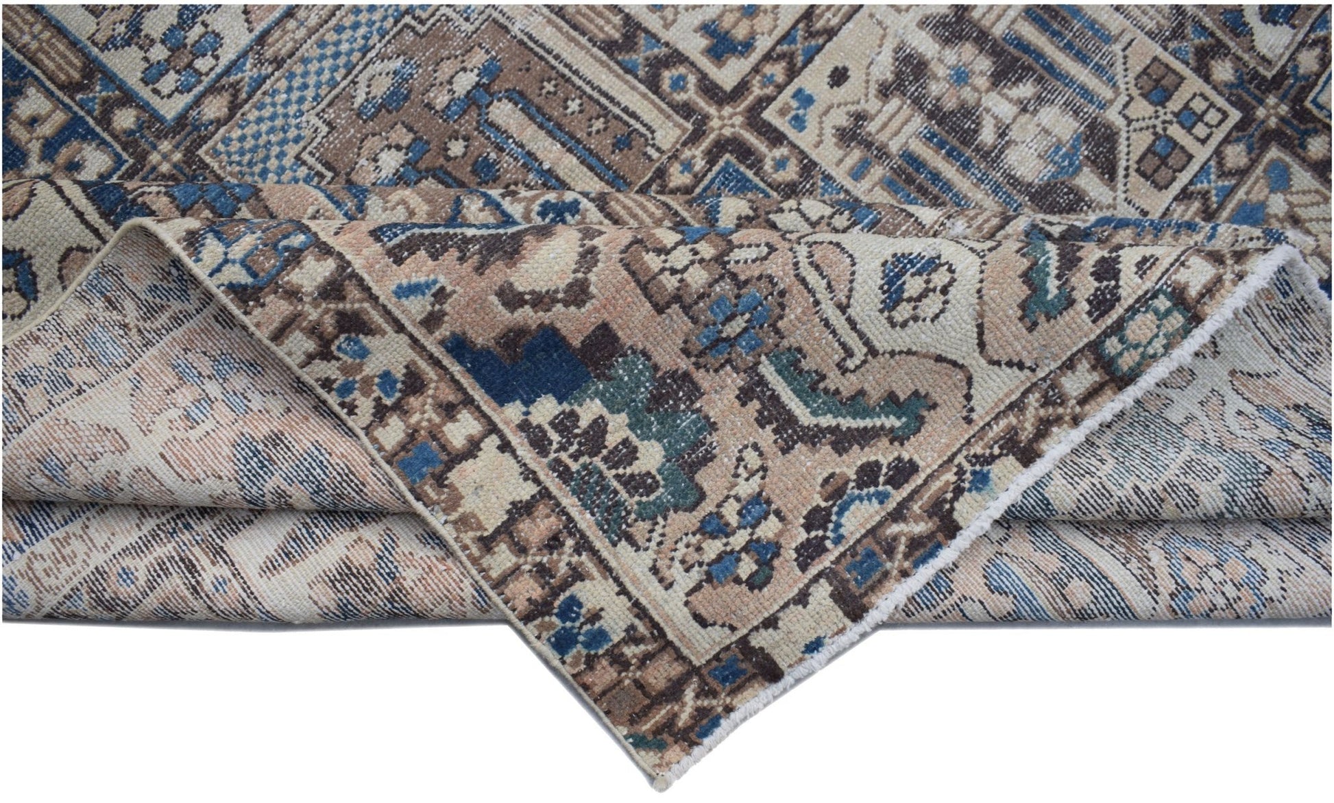 A folded vintage Persian Bakhtiari rug featuring intricate geometric patterns in blue and brown.
