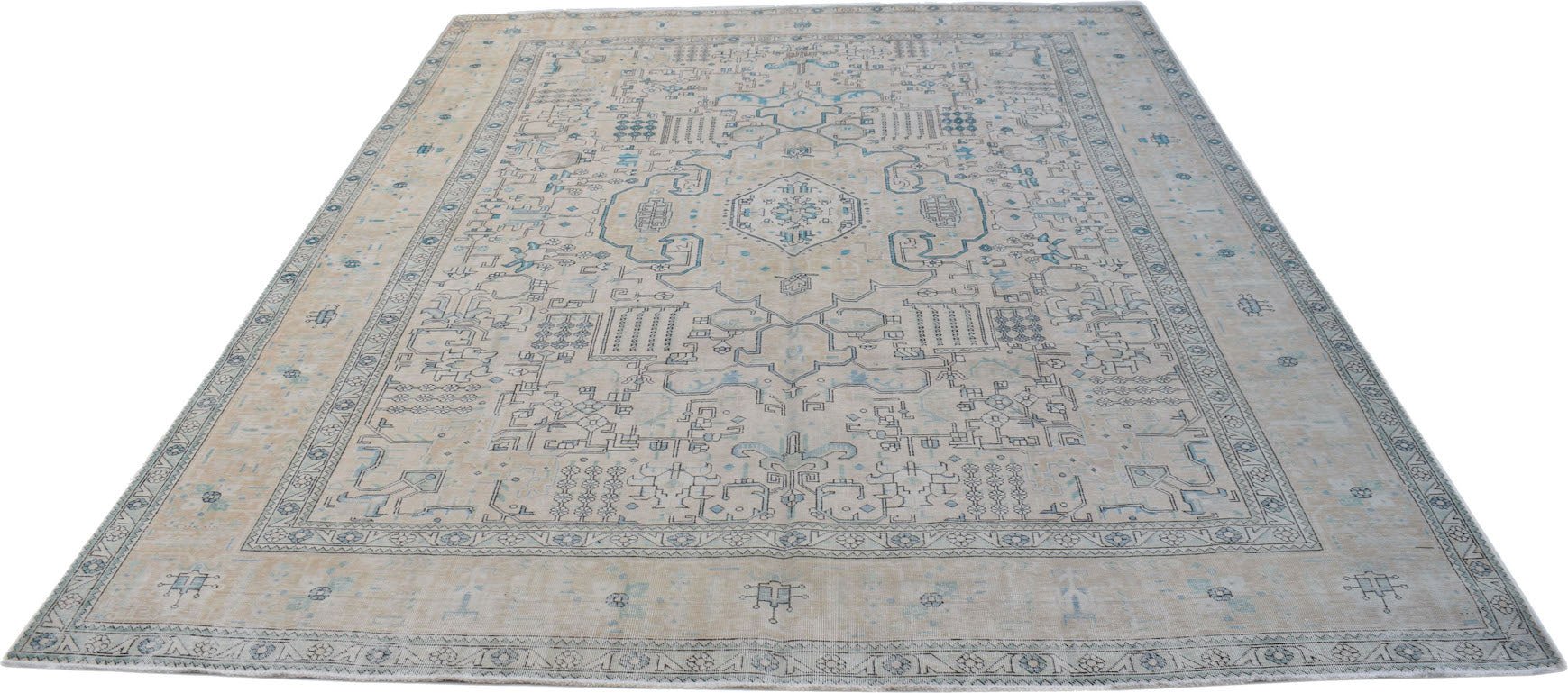 A vintage Persian Kerman rug featuring a central medallion and intricate blue floral patterns.