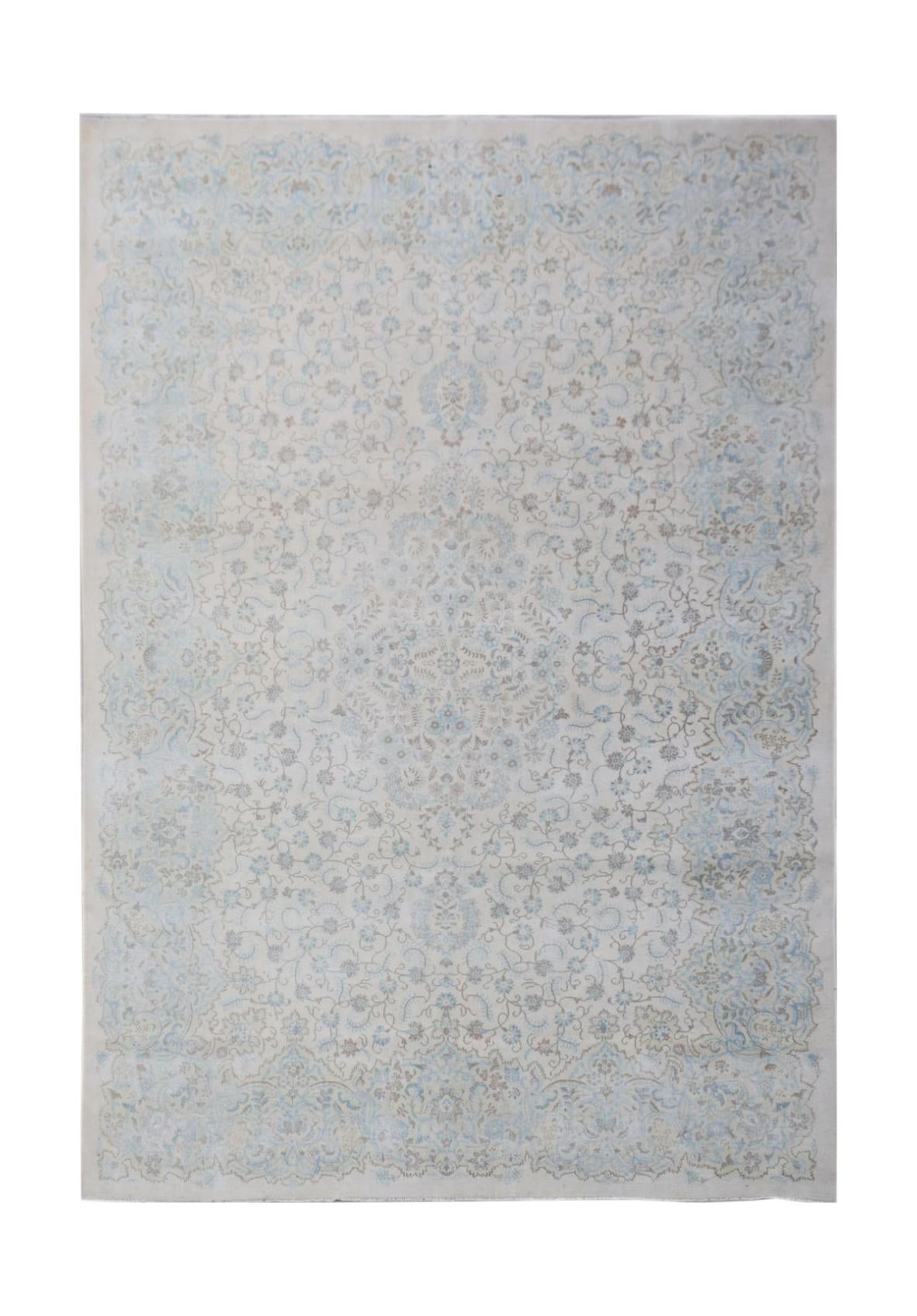 A vintage Persian Kerman rug featuring a central medallion and intricate floral patterns in blue.