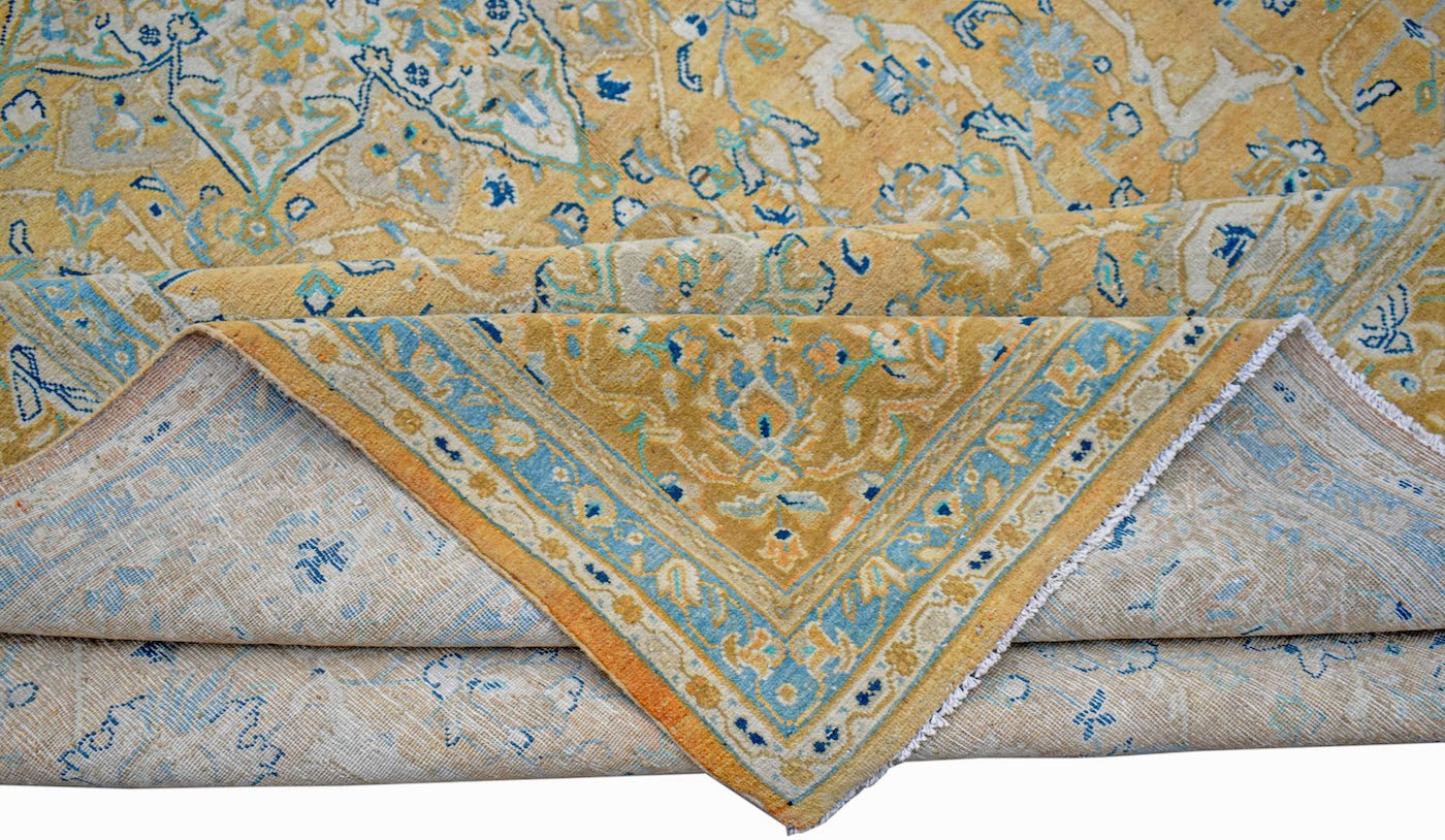 A vintage Persian Kashan rug featuring an intricate floral medallion design in gold and blue.