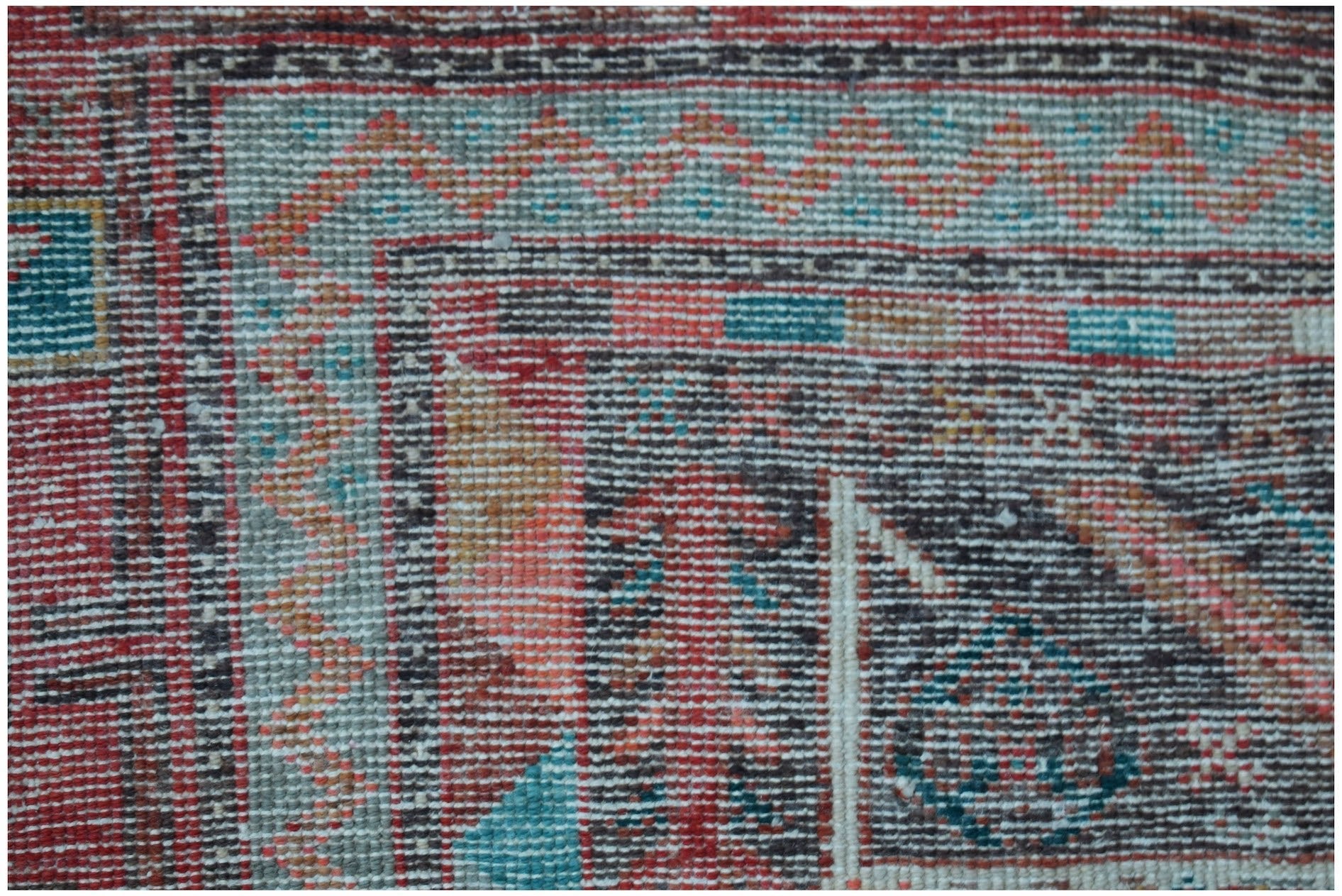 A close-up of a vintage Persian Koliai rug featuring a geometric Throne of Jamshed pattern.