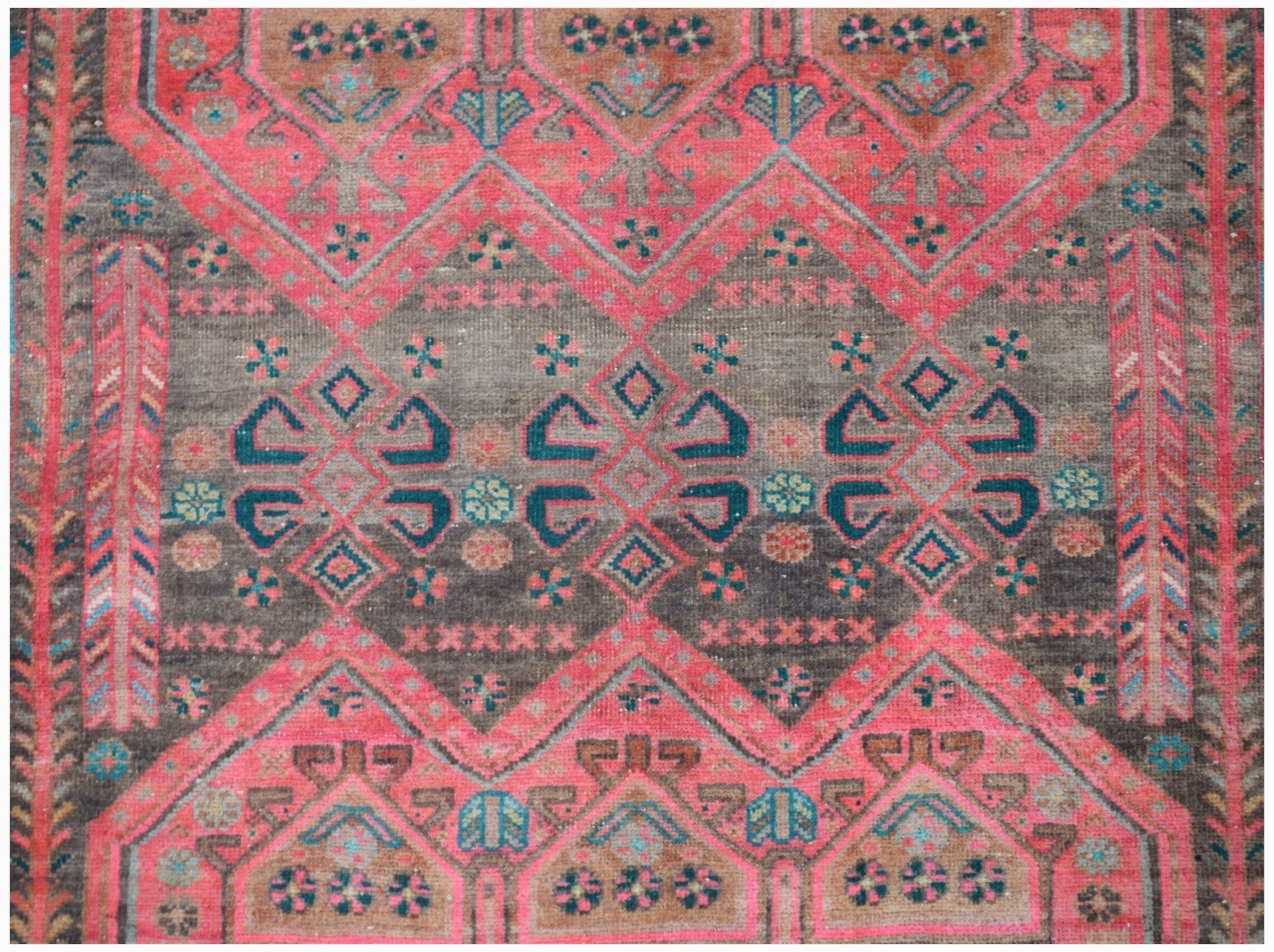 A vintage Persian Koliai rug featuring a geometric Throne of Jamshed pattern in red and brown tones.