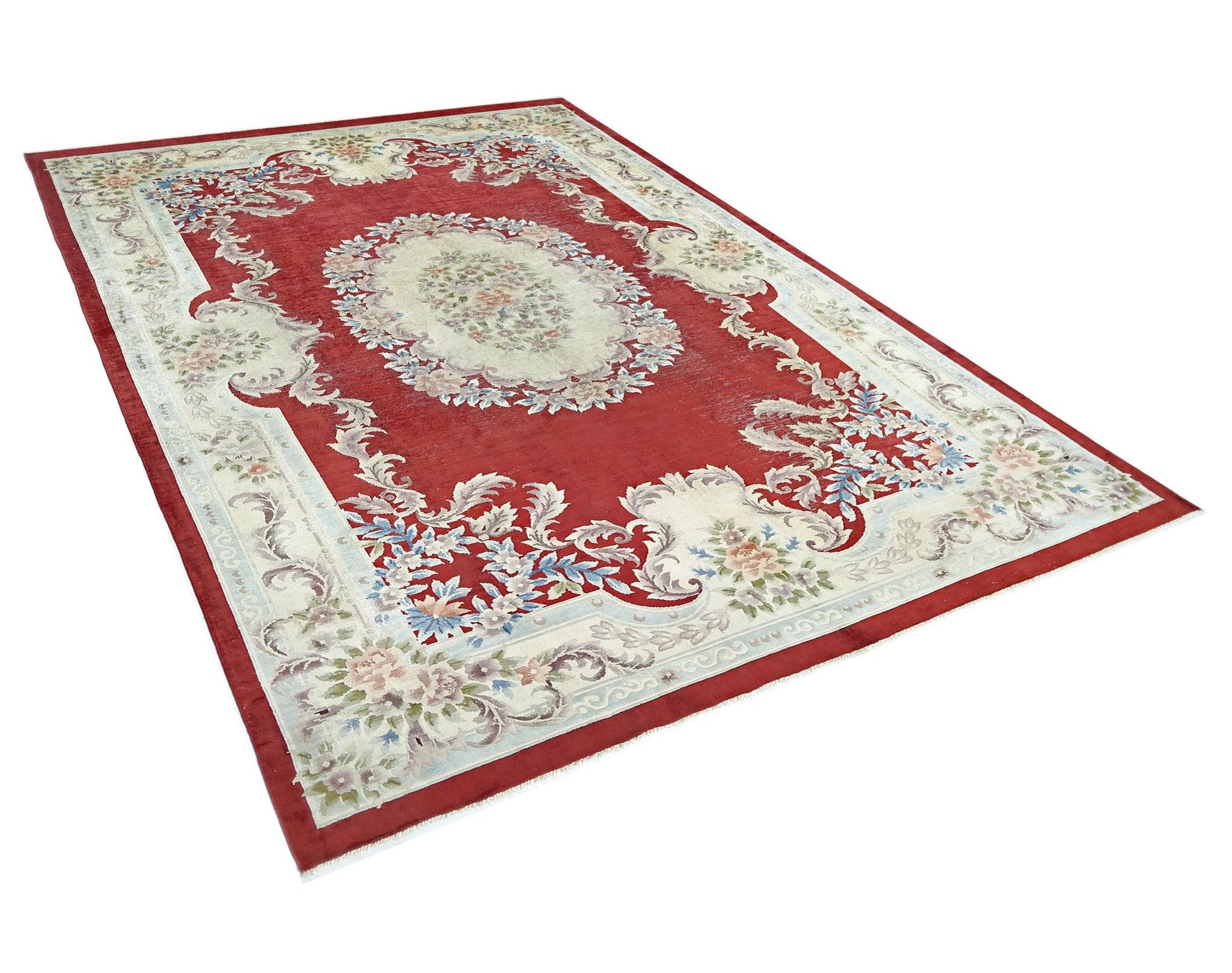 A vintage handmade Chinese silk rug featuring a floral medallion on a red field with cream borders.