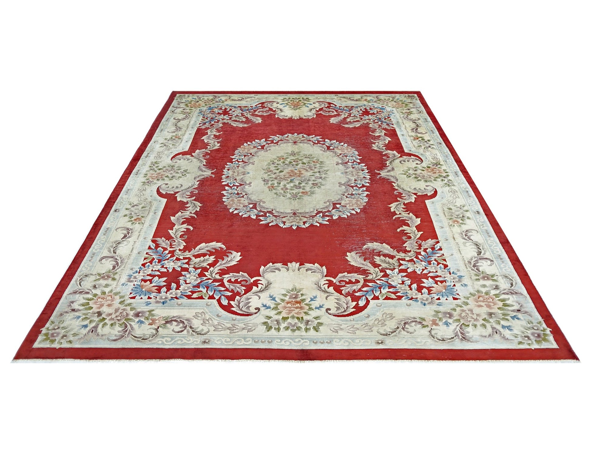 A vintage handmade Chinese silk rug featuring a floral medallion on a red field.