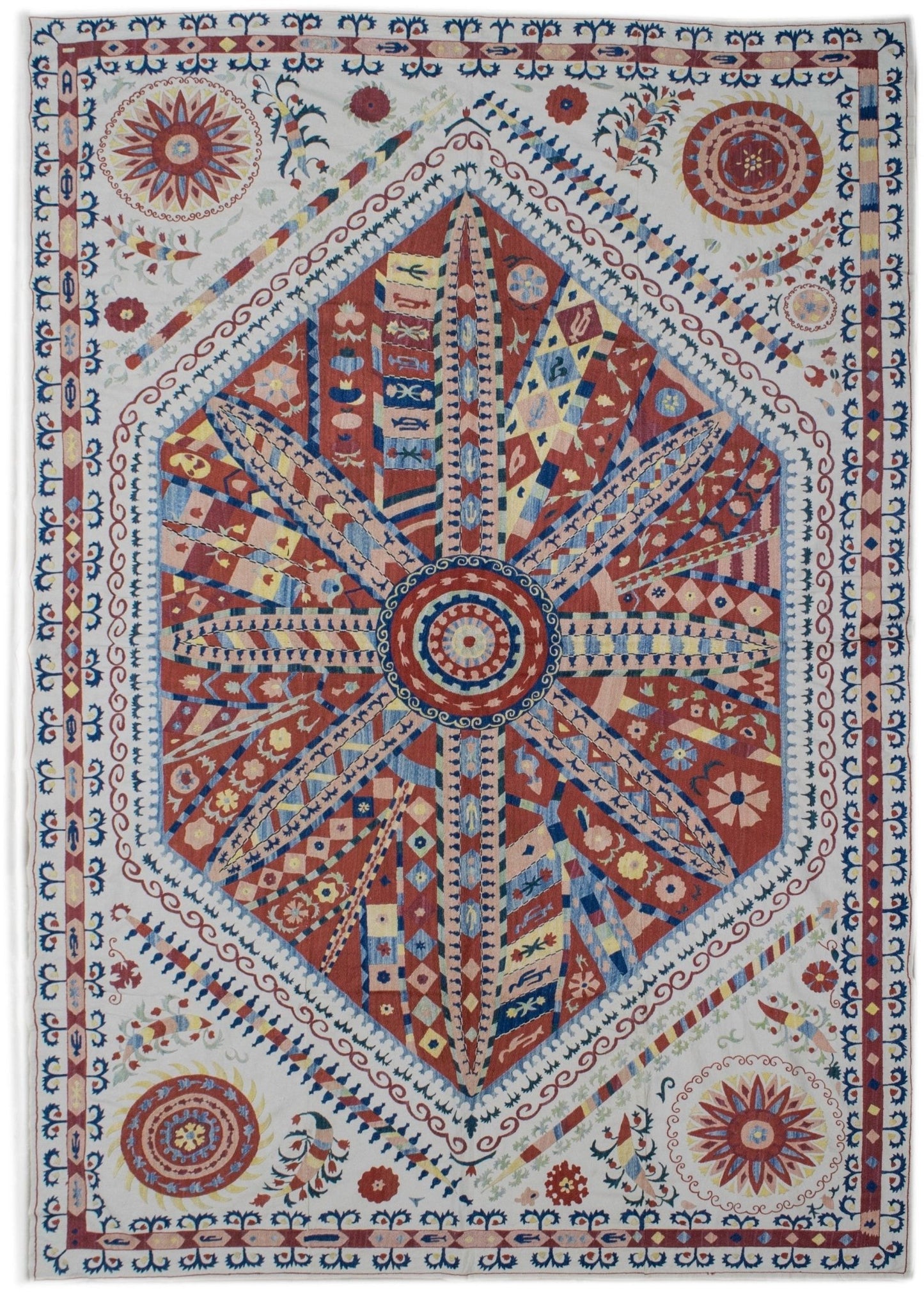 Handmade Uzbek suzani featuring intricate silk floral and sunburst embroidery on a cotton base.