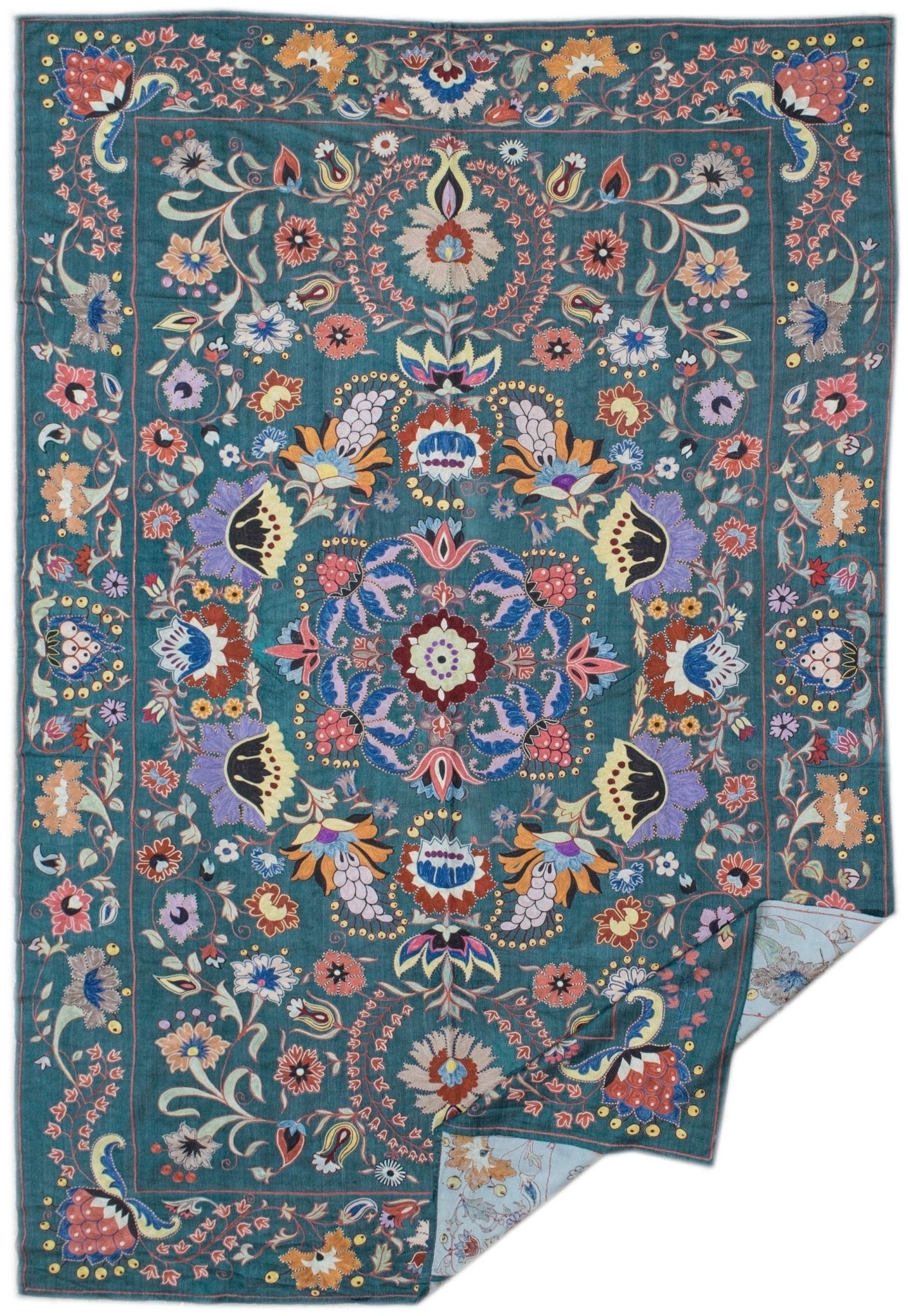Handmade silk Uzbek suzani featuring intricate floral embroidery on a teal silk background.