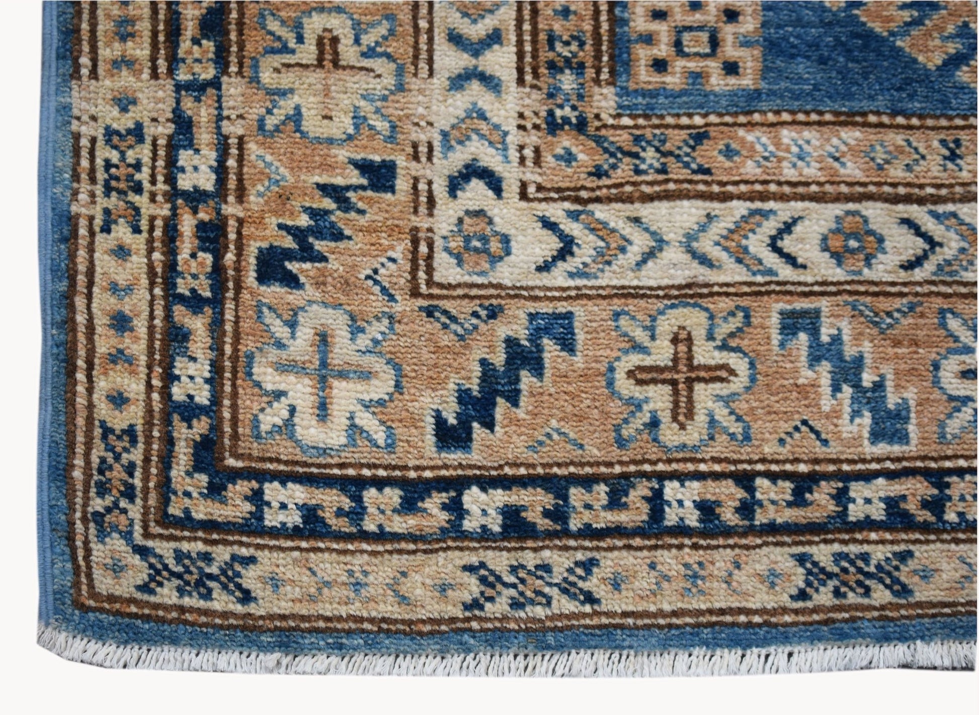 A handmade Afghan Super Kazakh runner featuring traditional geometric motifs in blue and tan wool.