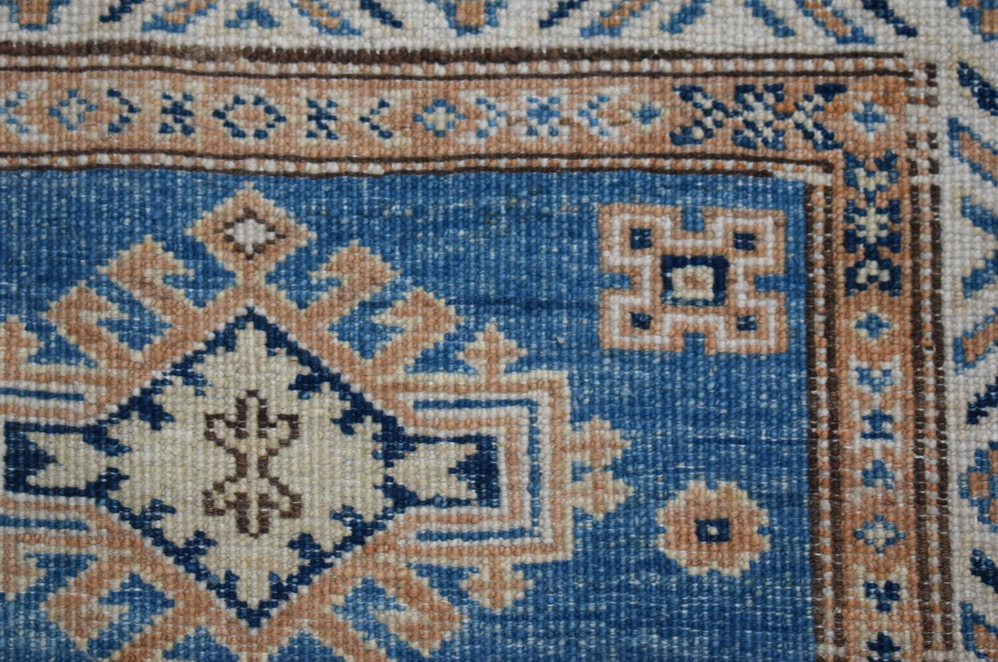 A handmade Afghan Super Kazakh runner featuring traditional geometric motifs in blue and tan.