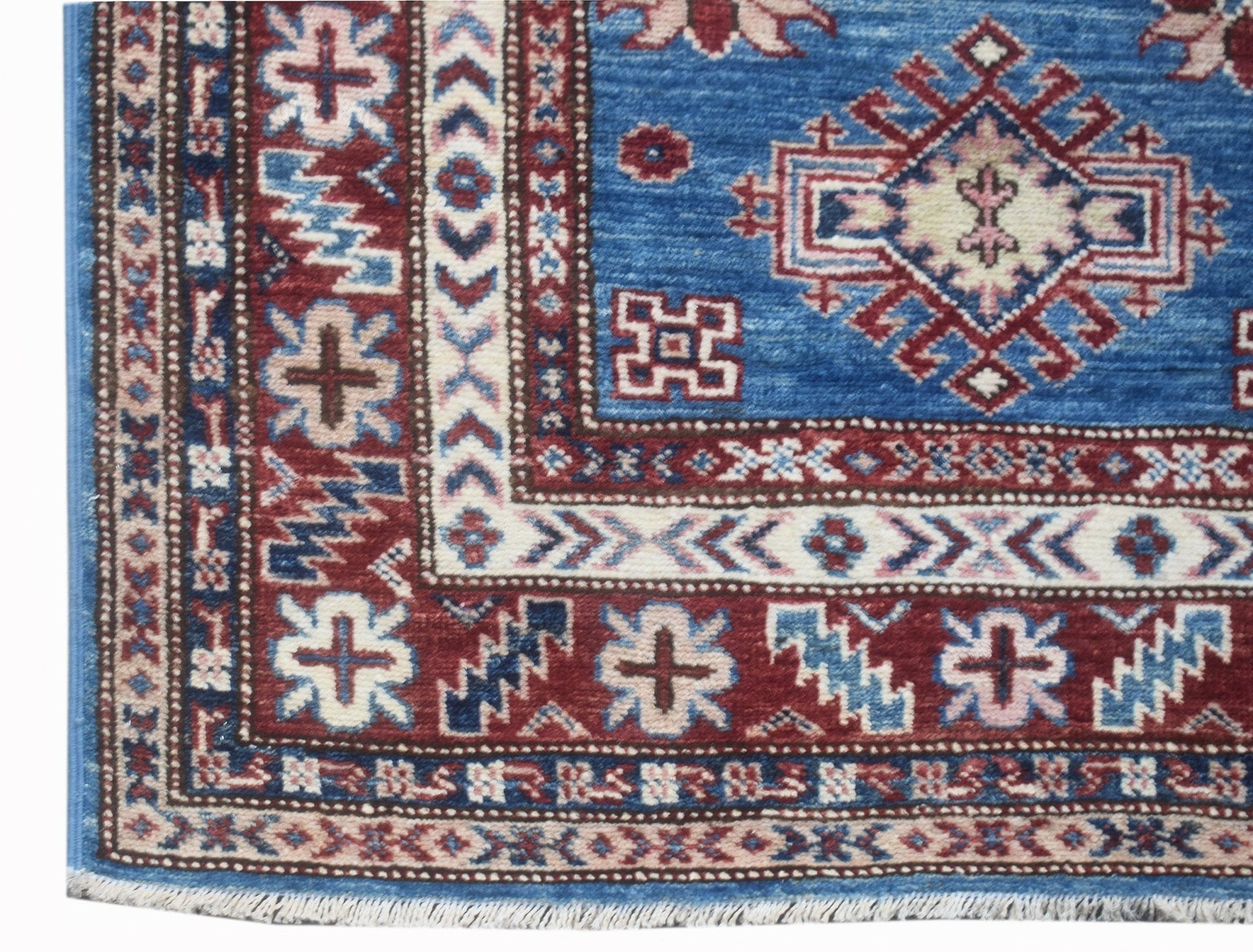 A handmade Afghan Super Kazakh runner rug featuring traditional geometric motifs in blue and red.
