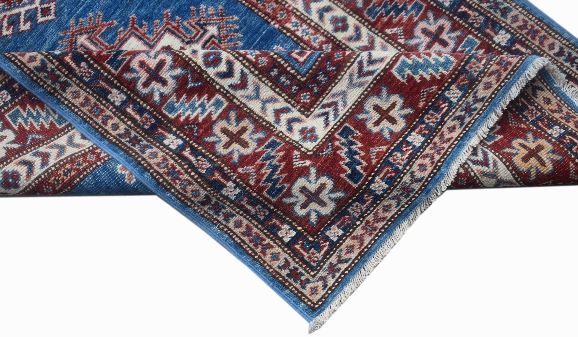 A handmade Afghan Super Kazakh runner featuring traditional geometric motifs in blue and red wool.