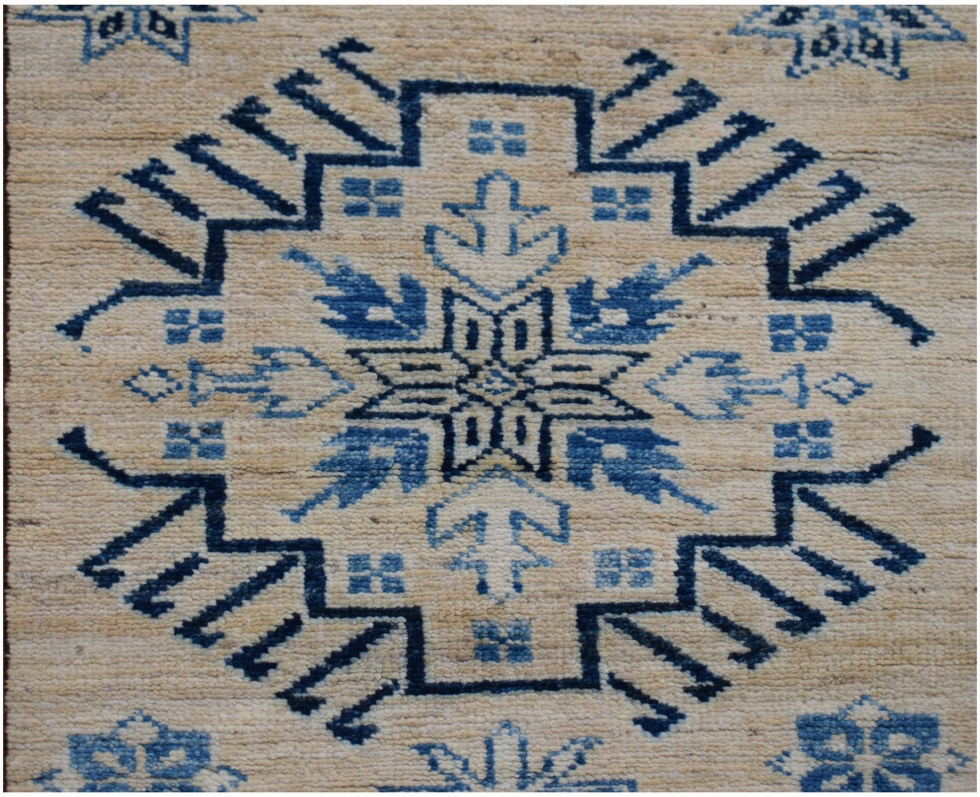 Handmade Afghan Super Kazakh runner rug featuring a blue geometric medallion on a beige field.