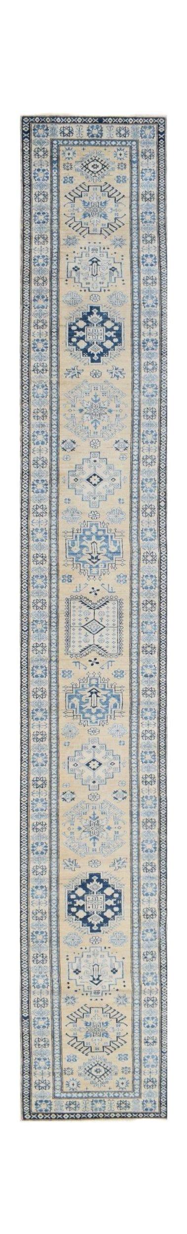 A long, handmade Afghan Super Kazakh runner rug featuring blue geometric motifs on a beige field.
