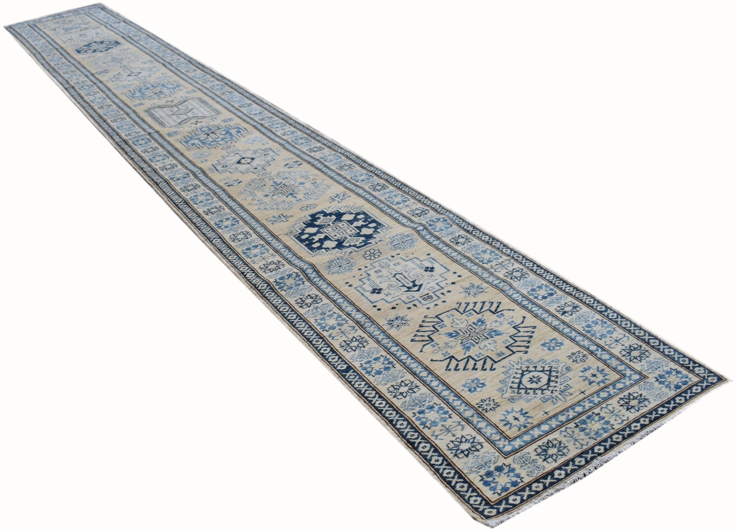 A long, handmade Afghan Super Kazakh runner rug featuring geometric patterns in blue and beige.
