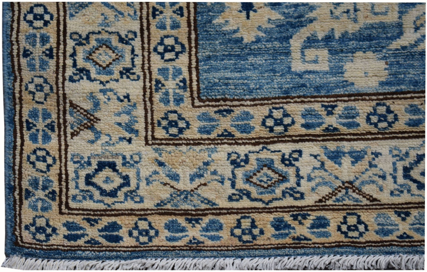 A handmade Afghan Super Kazakh runner featuring a geometric blue and beige pattern with fringe.
