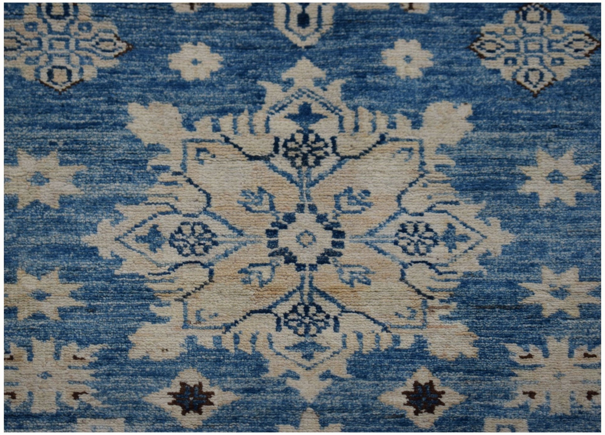 Handmade Afghan Super Kazakh runner featuring a beige floral medallion pattern on a blue background.
