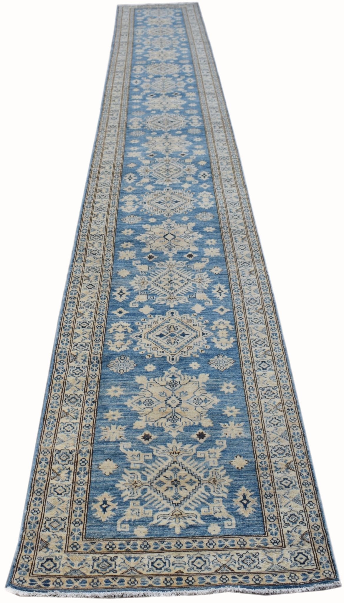 A long, handmade Afghan Super Kazakh runner rug featuring intricate geometric patterns in blue.