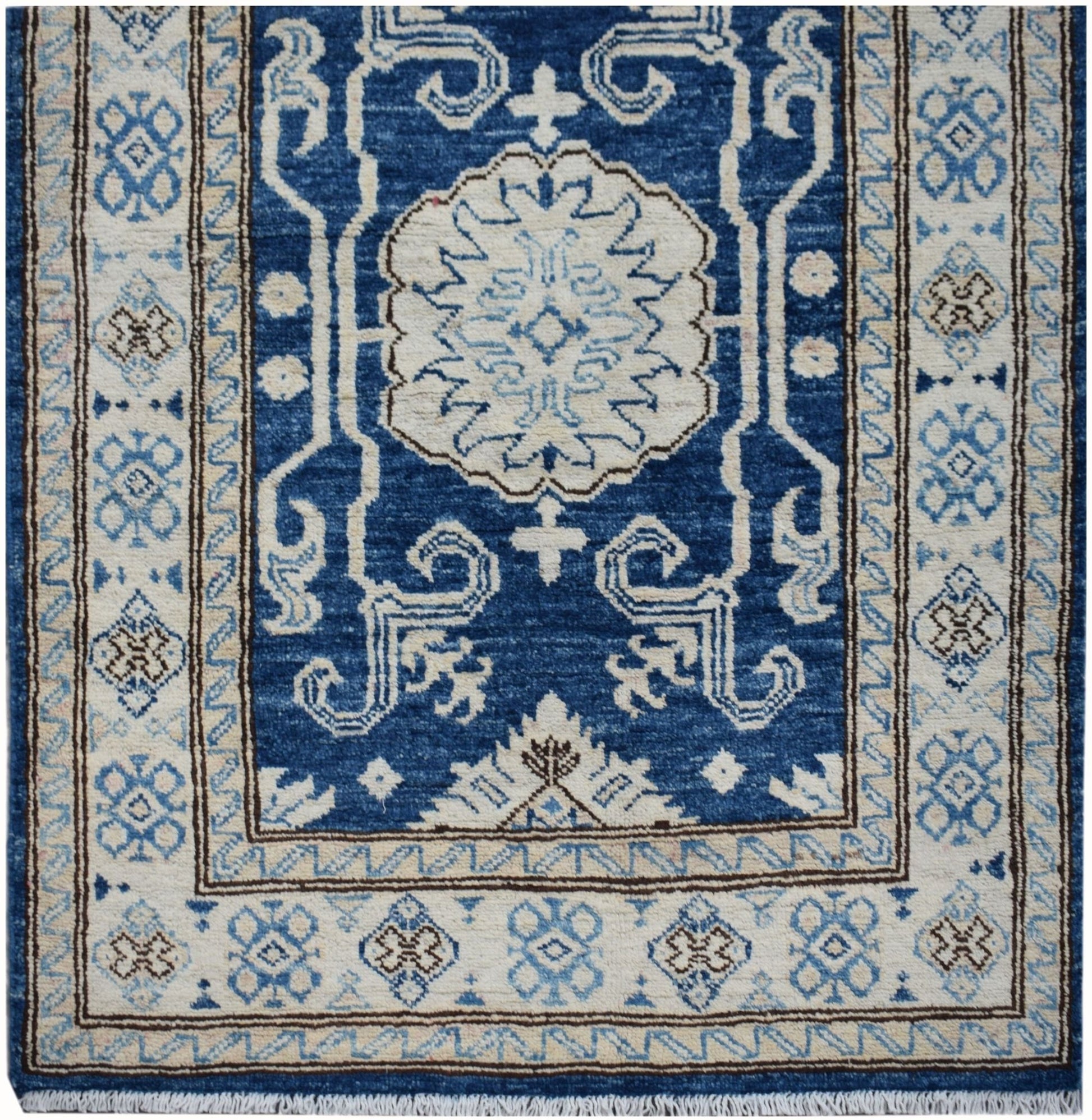 An Afghan Super Kazakh runner rug featuring a central floral medallion on a deep blue field.