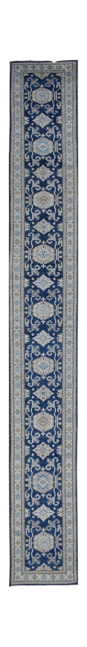 A long, handmade Afghan Super Kazakh runner rug featuring a blue field with beige geometric motifs.