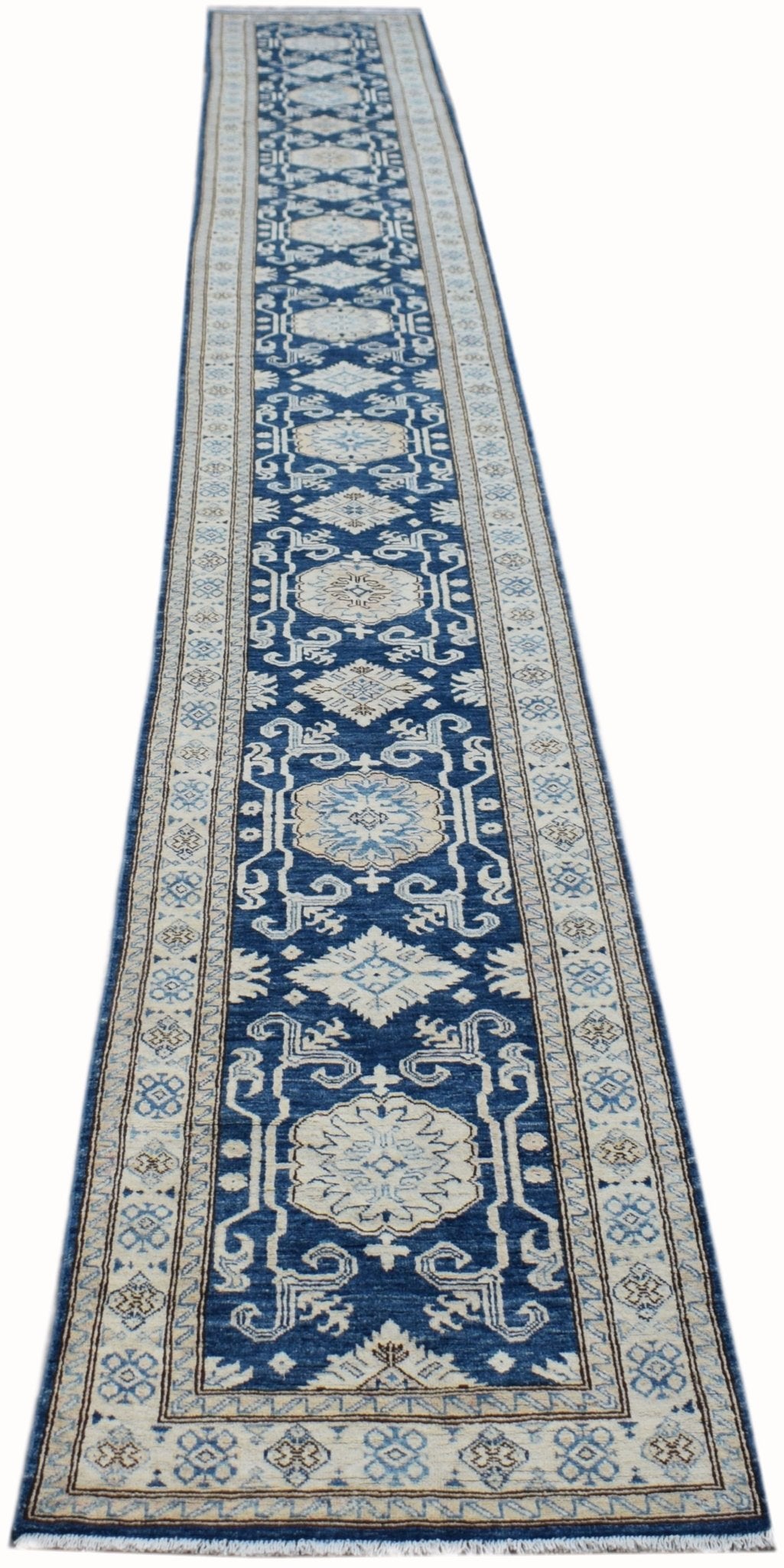 A long, handmade Afghan Super Kazakh runner rug featuring a blue field with beige geometric motifs.