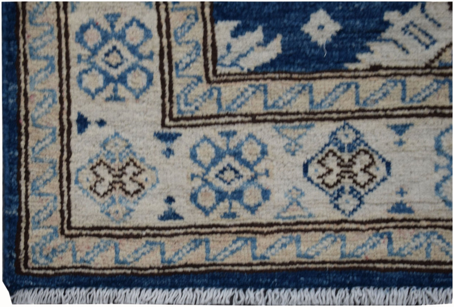A handmade Afghan Super Kazakh runner featuring a geometric blue and beige pattern with fringe.