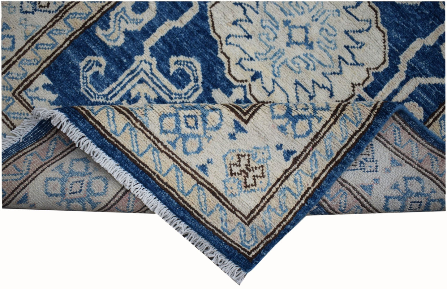 An Afghan Super Kazakh runner rug with a blue and beige geometric pattern and fringed edges.