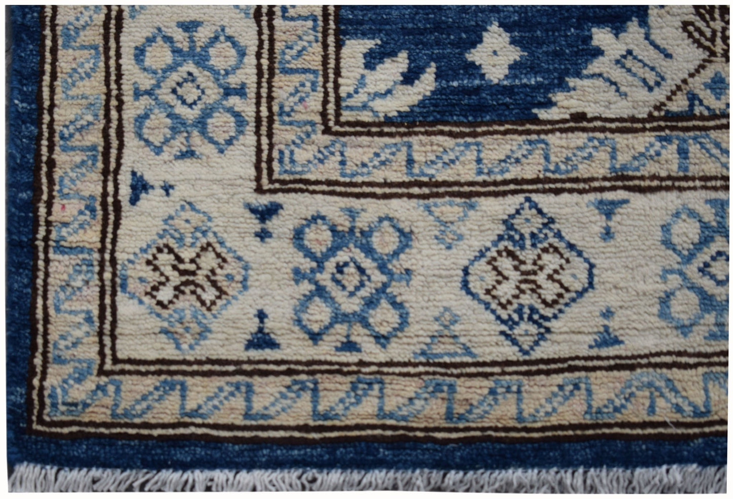 A handmade Afghan Super Kazakh runner featuring a geometric pattern in blue, beige, and brown.