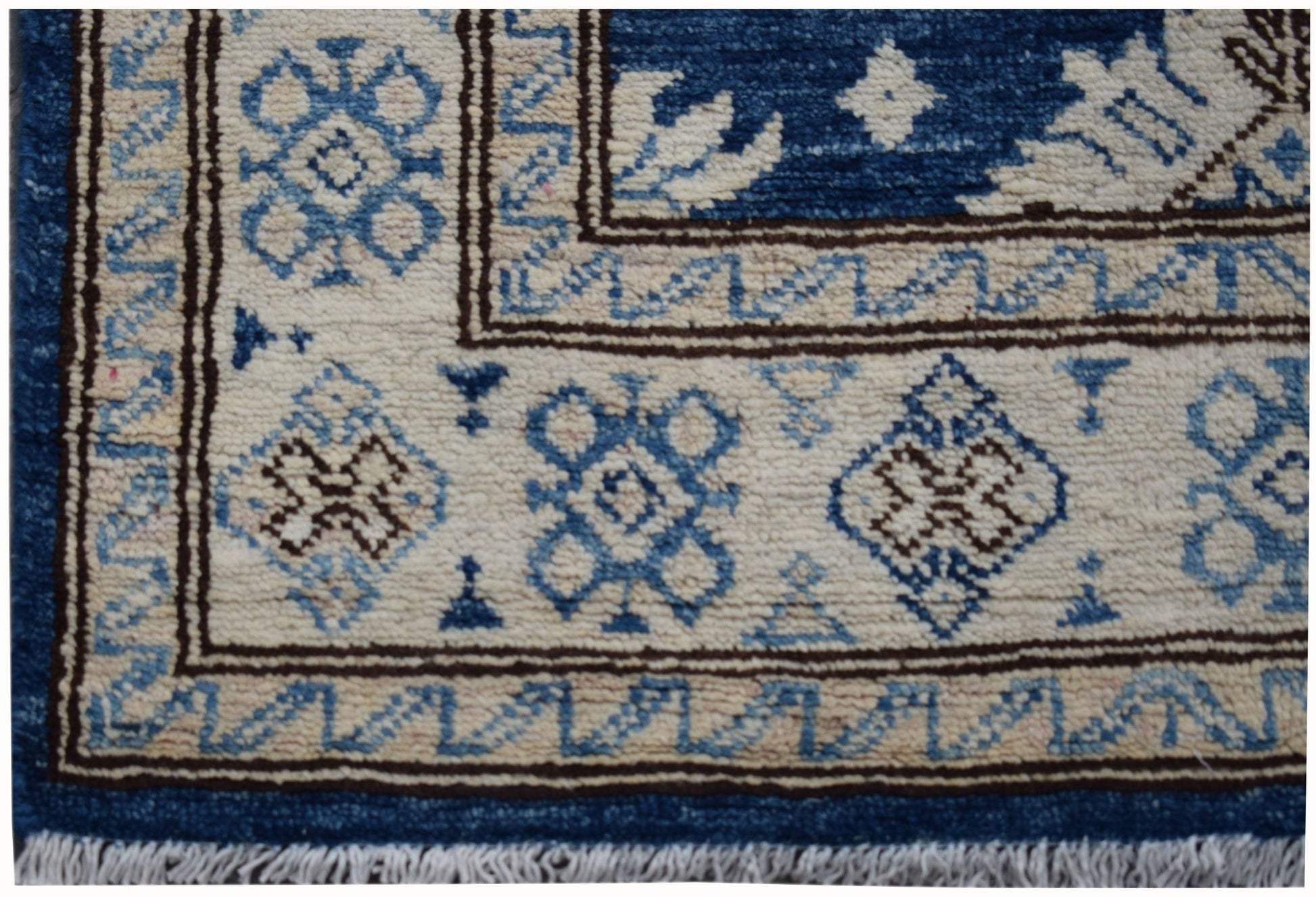 A handmade Afghan Super Kazakh runner featuring a geometric pattern in blue, beige, and brown.
