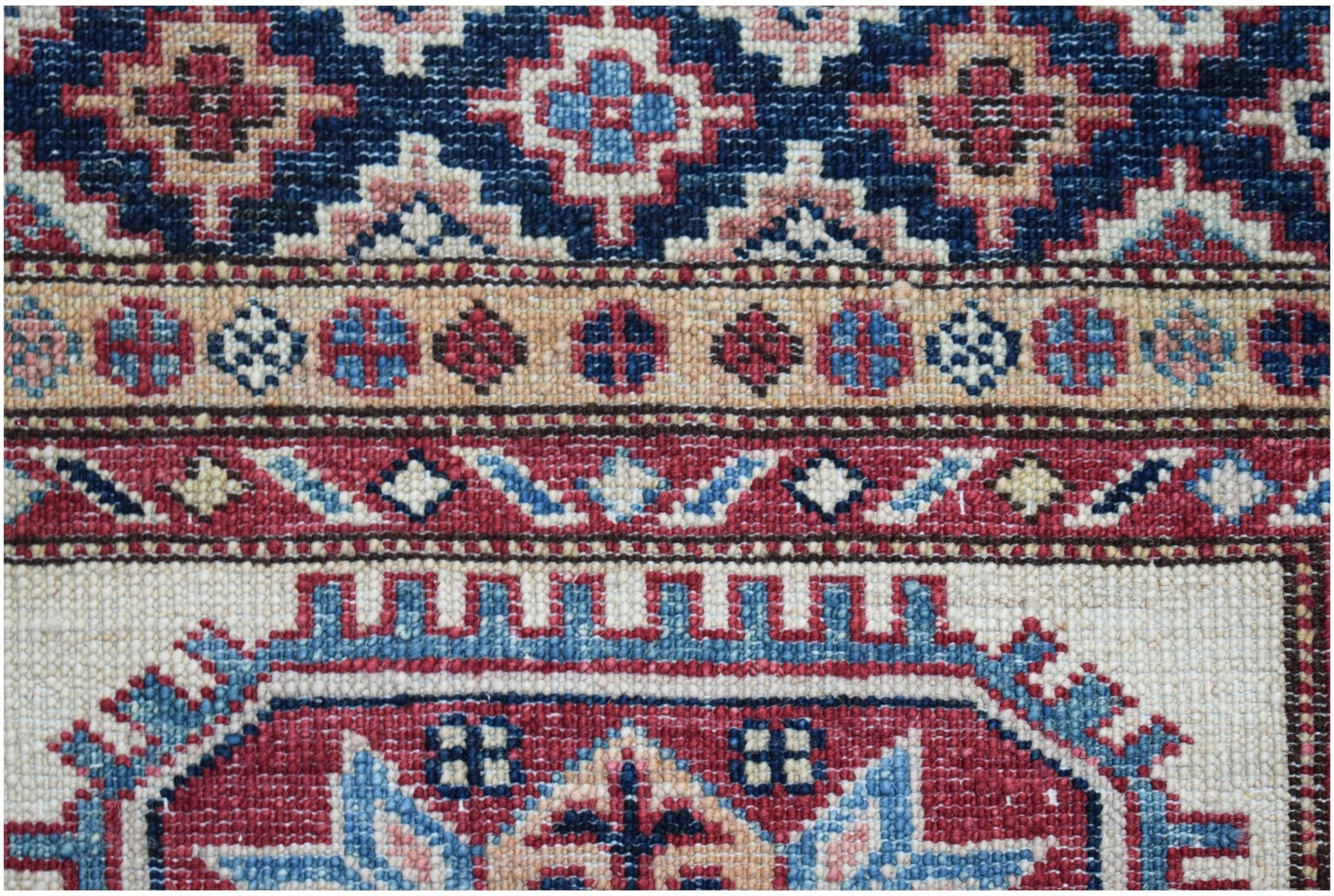 A close-up of an Afghan Super Kazakh runner featuring intricate geometric patterns in wool.
