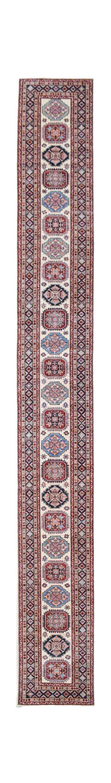 A long, handmade Afghan runner rug featuring repeating geometric medallions in red and blue tones.