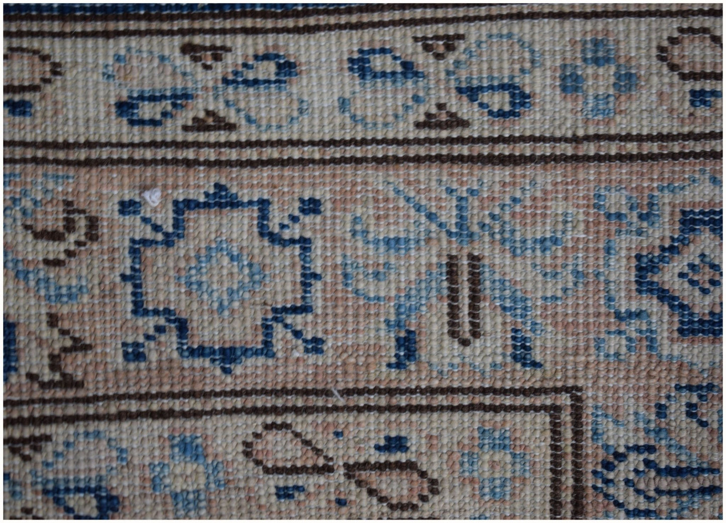 A close-up of an Afghan Super Kazakh runner featuring geometric blue and beige wool patterns.