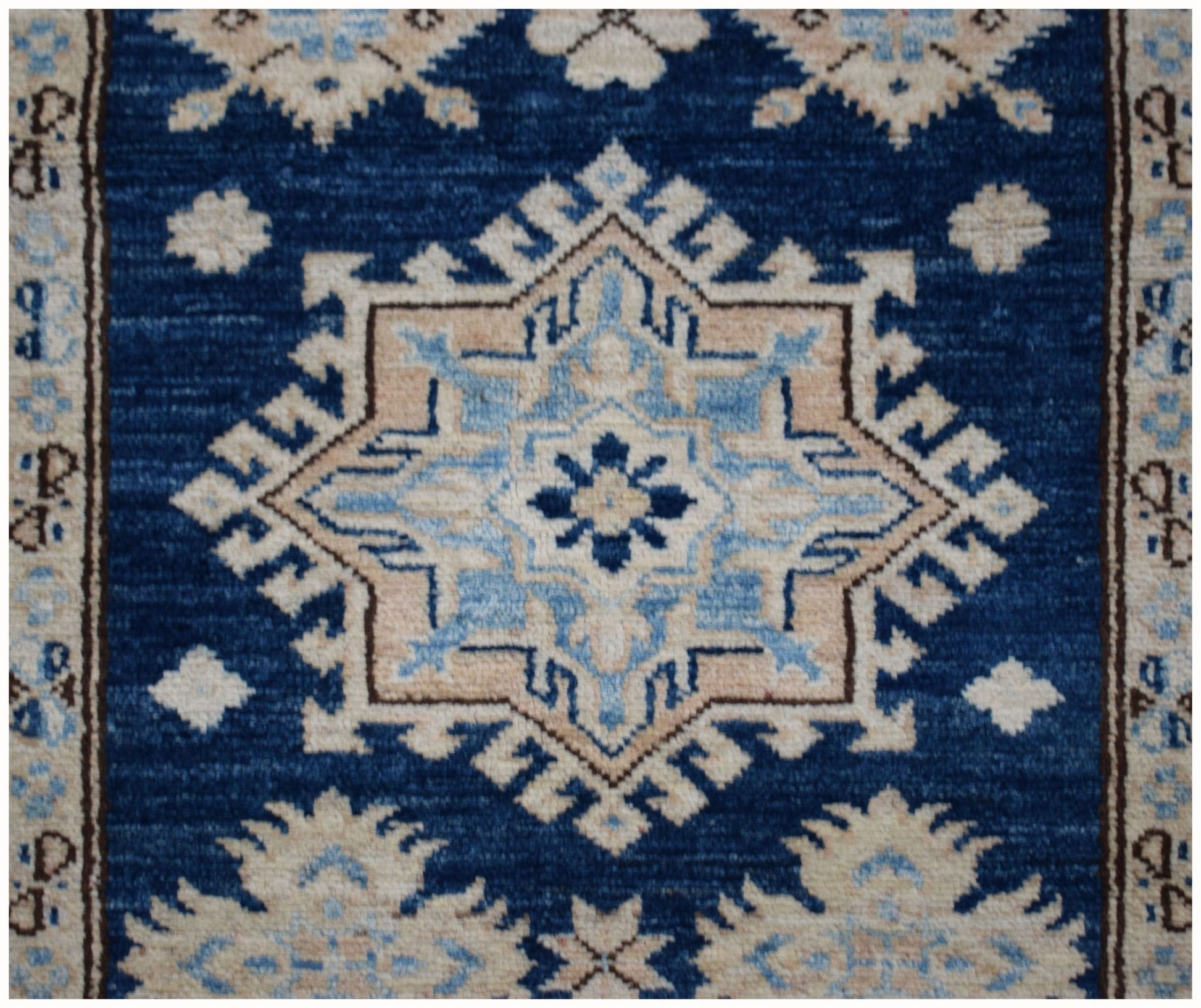 An Afghan Super Kazakh runner rug featuring a geometric star medallion in blue and beige tones.