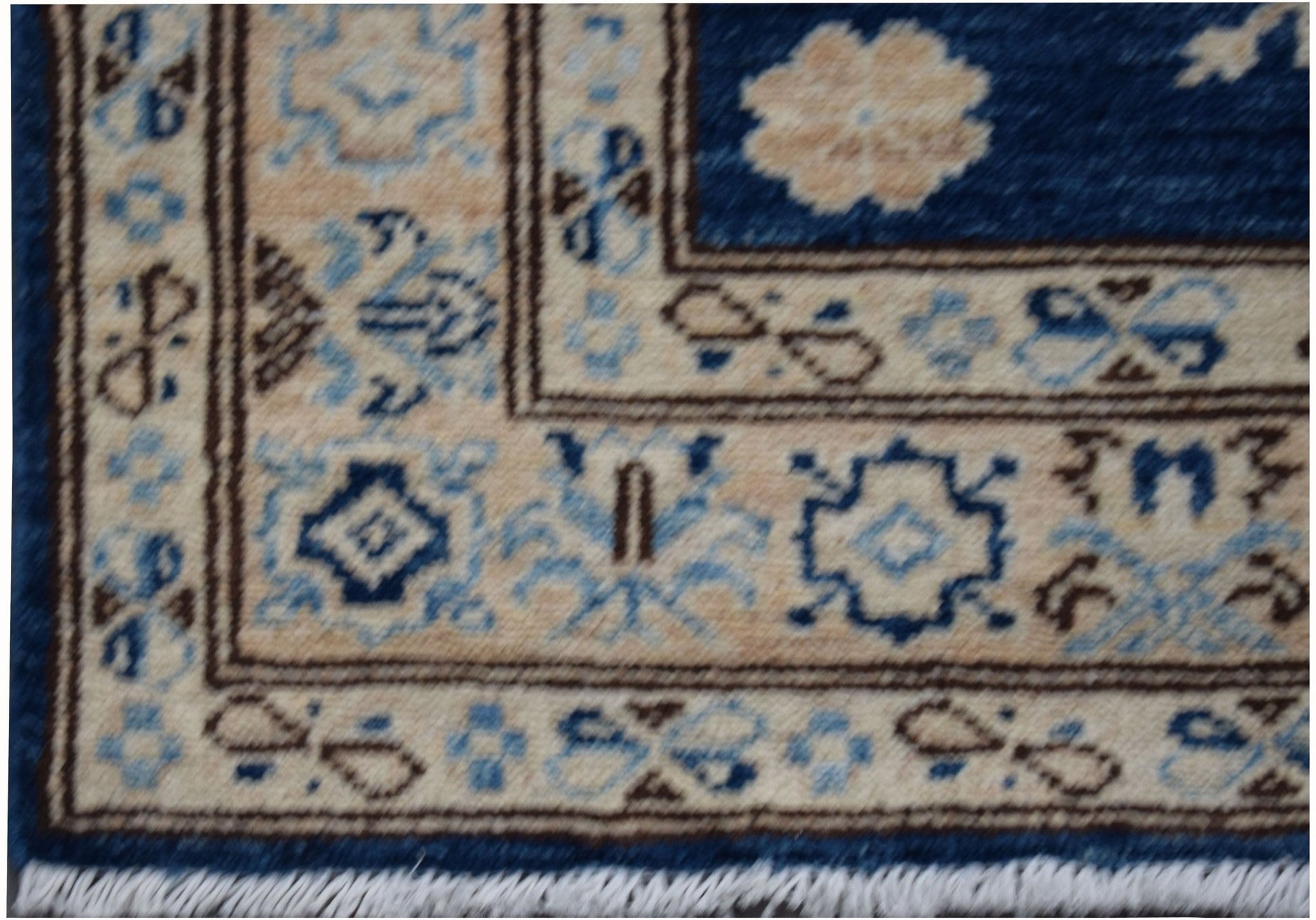A close-up of an Afghan Super Kazakh runner rug featuring geometric patterns in blue and beige.