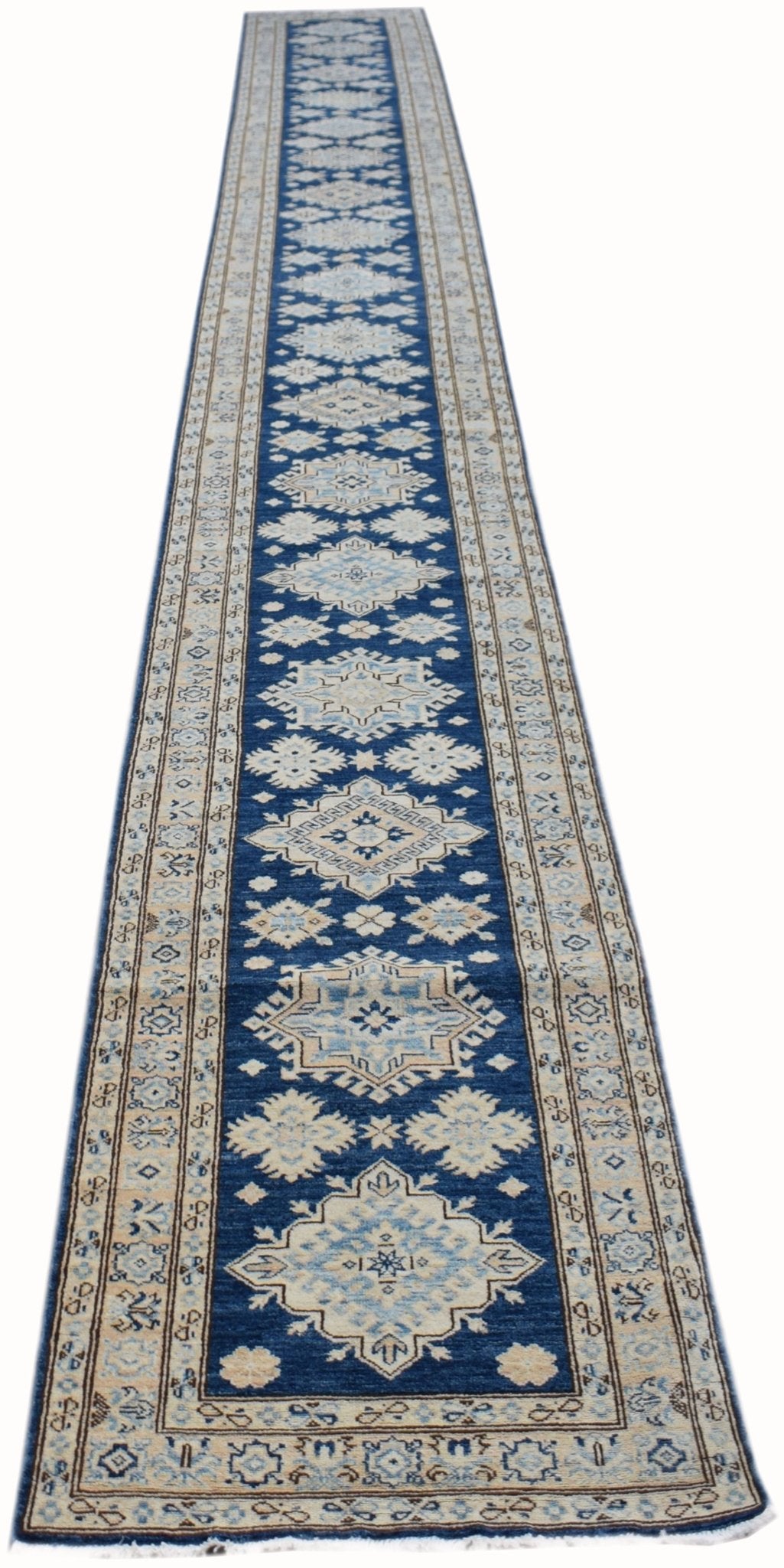A long, handmade Afghan Super Kazakh runner rug featuring geometric patterns in blue and beige.