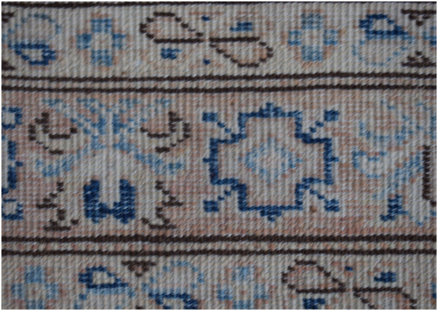 A close-up of an Afghan Super Kazakh runner featuring geometric blue and brown patterns on beige.