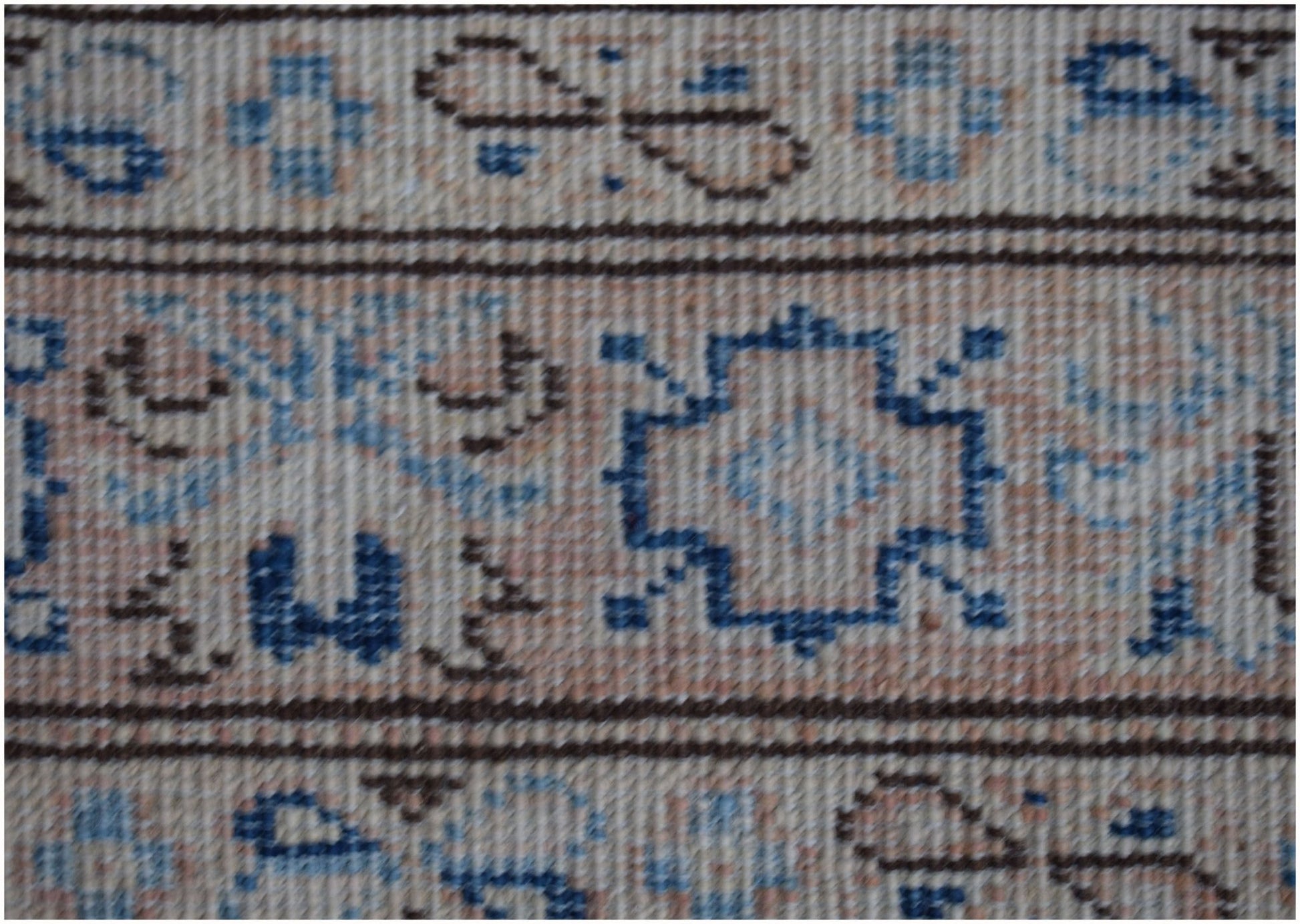 A close-up of an Afghan Super Kazakh runner featuring geometric blue and brown patterns on beige.